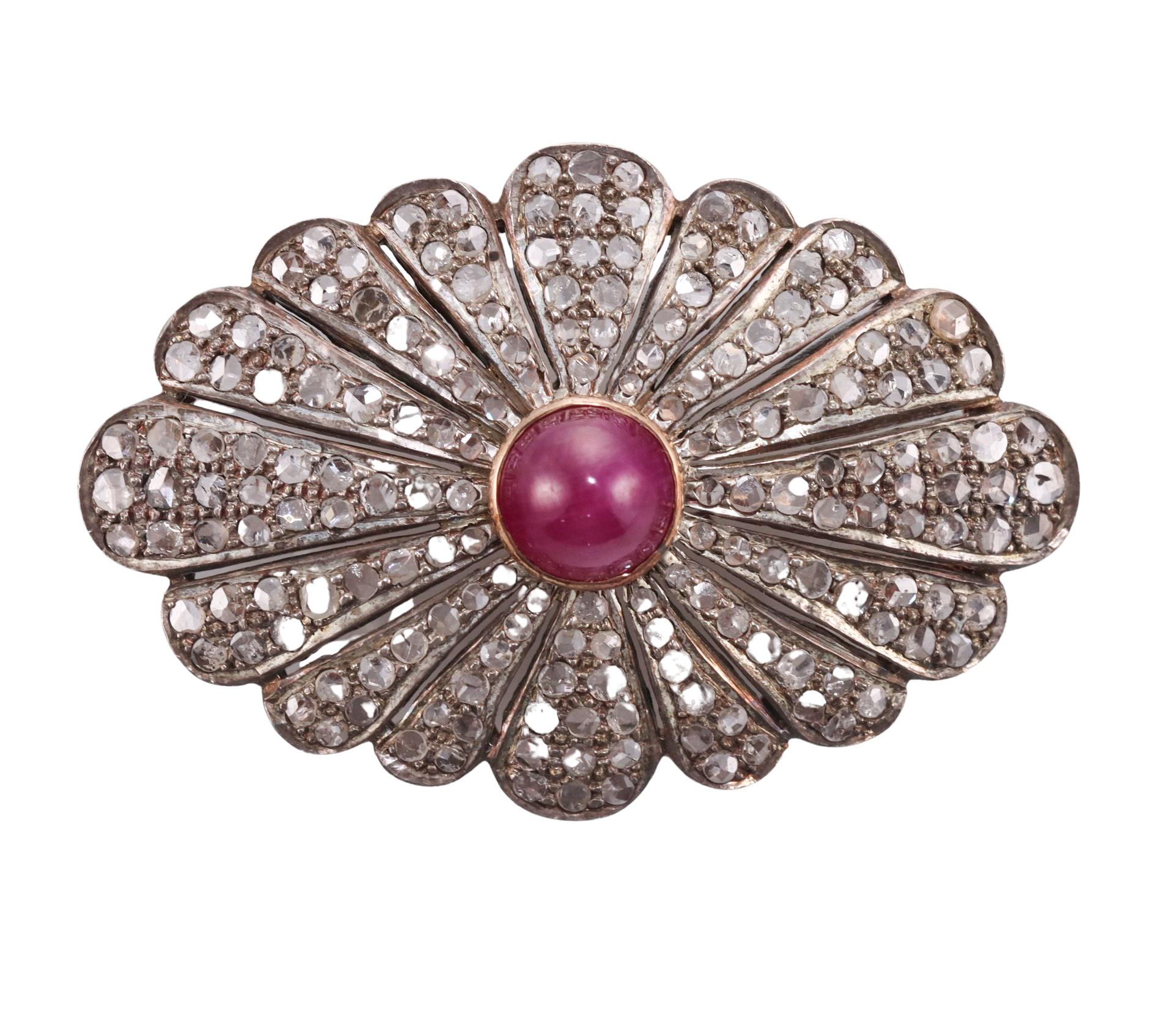 Antique 14k gold and silver brooch, featuring rose cut diamonds and center 8mm ruby cabochon. Brooch measures 46mm x 30mm. Tested gold and silver, not marked. Weighs 10.8 grams. 
