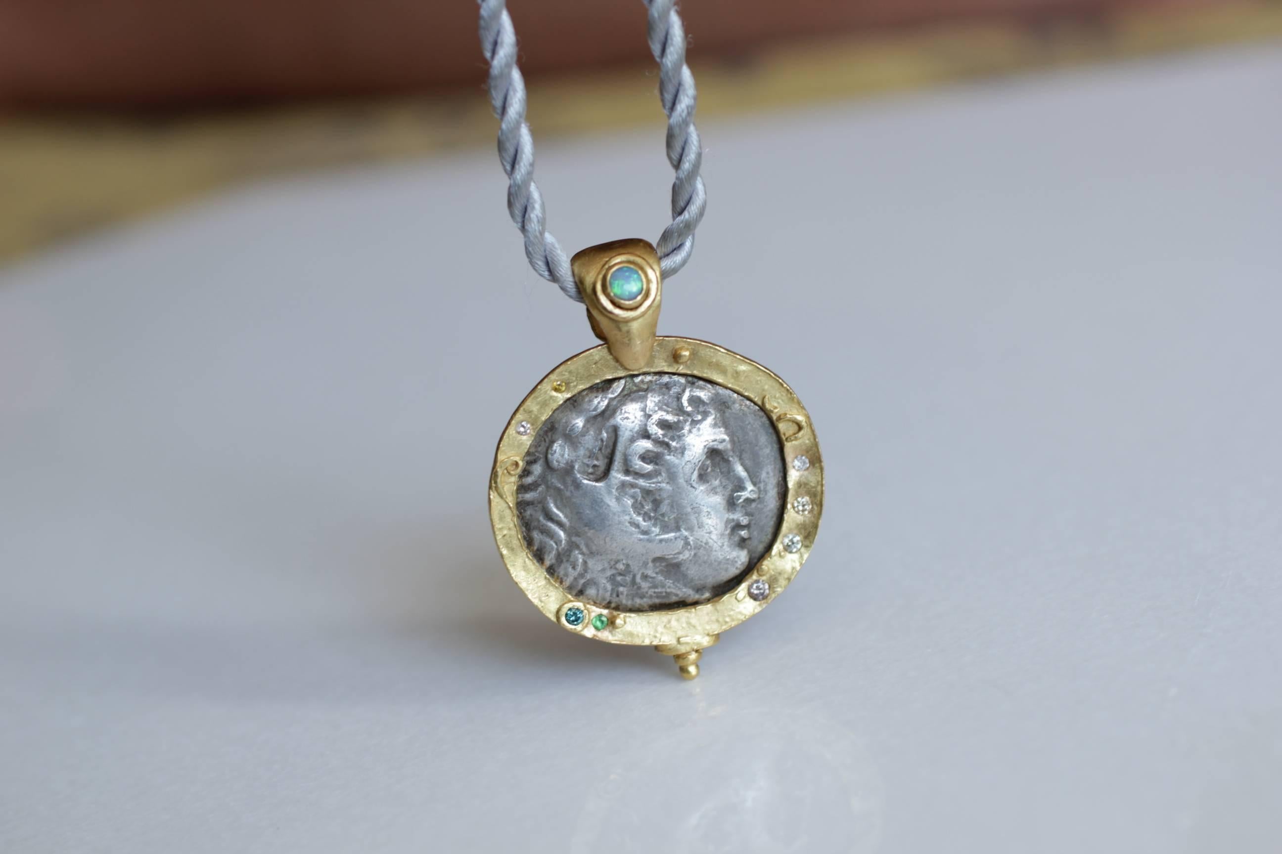 Antique silver Macedonian Coin Medallion Pendant Necklace. Large antique 3rd Cent BC Greek coin, set in 21k gold bezel, embellished with small diamonds and garnet accents. The Bail is highlighted with Lightning Ridge Opal, also set in a bezel.

The