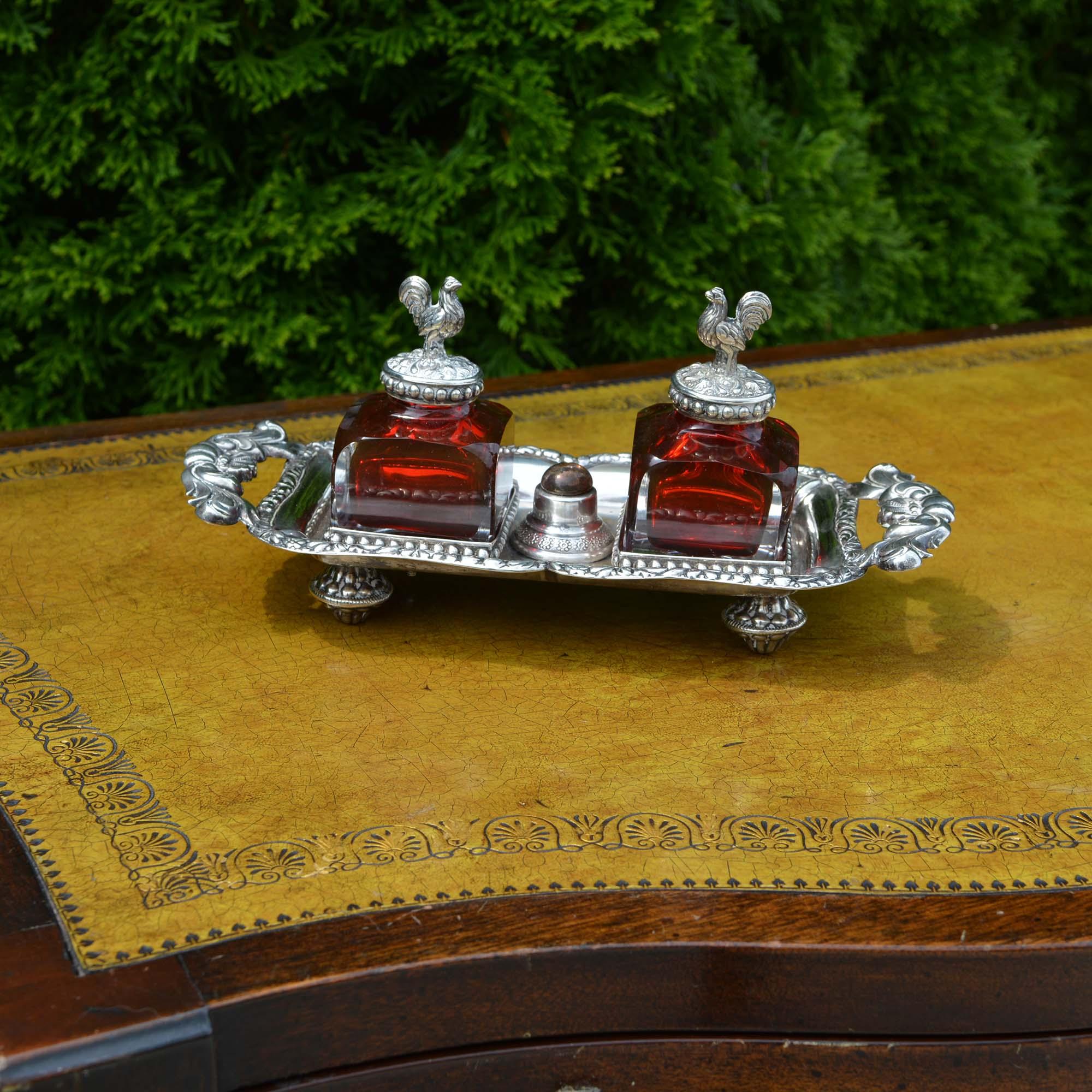 Antique silver inkwell with two clear glass inkwells with rich, ruby red interiors. The center once had a handle, but it was missing when we found it. We have placed a discrete bead in its place. The base is marked but each inkwell is topped with a