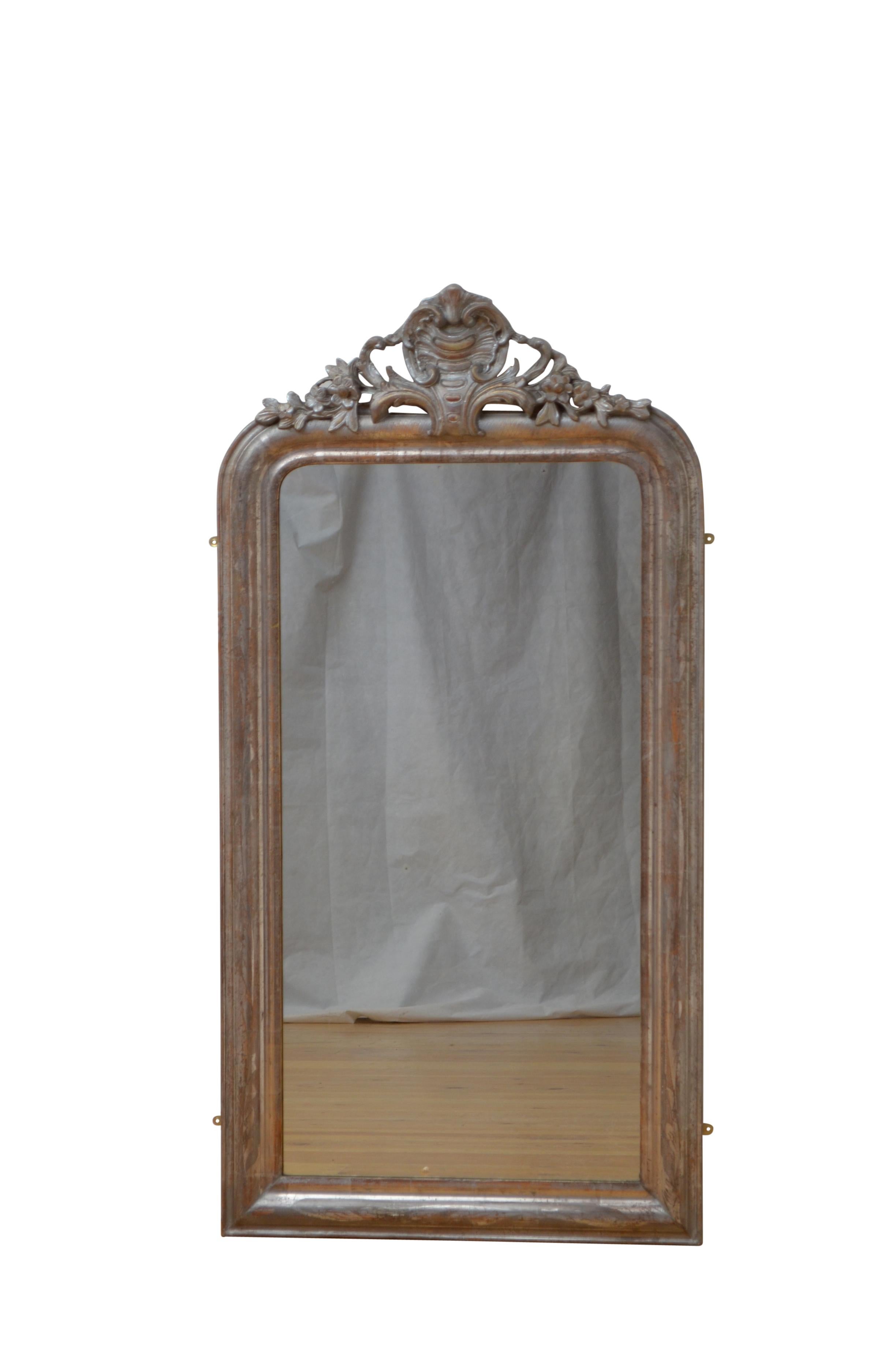 P0219  Rare miroir mural du XIXe siècle, avec vitre d'origine légèrement roussie et cadre en argent moulé avec motifs floraux gravés et crête de feuillage au centre. Ce miroir ancien a conservé son verre d'origine, son argenture d'origine avec