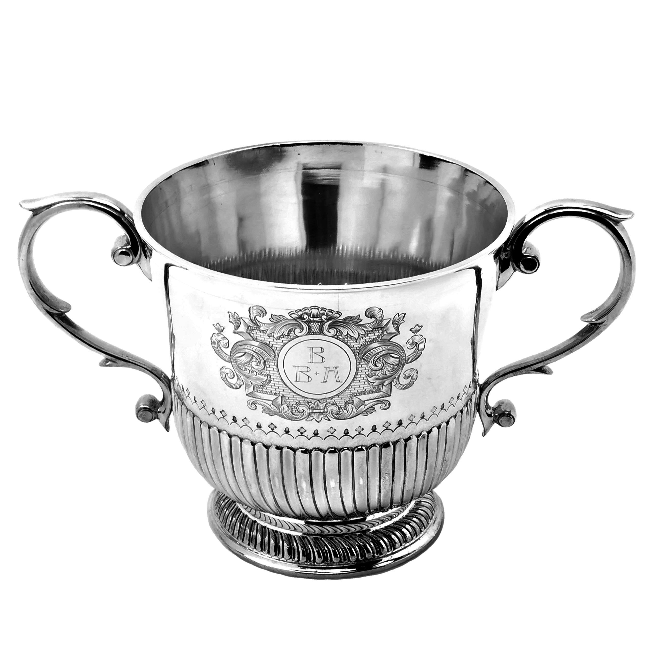 A magnificent Antique Silver Lidded Porringer or Cup & Cover made in the William III 17th century style. The body and lid of the Two Handled Cup are decorated with chased fluted bands and the body has an impressive engraved design on the one side.