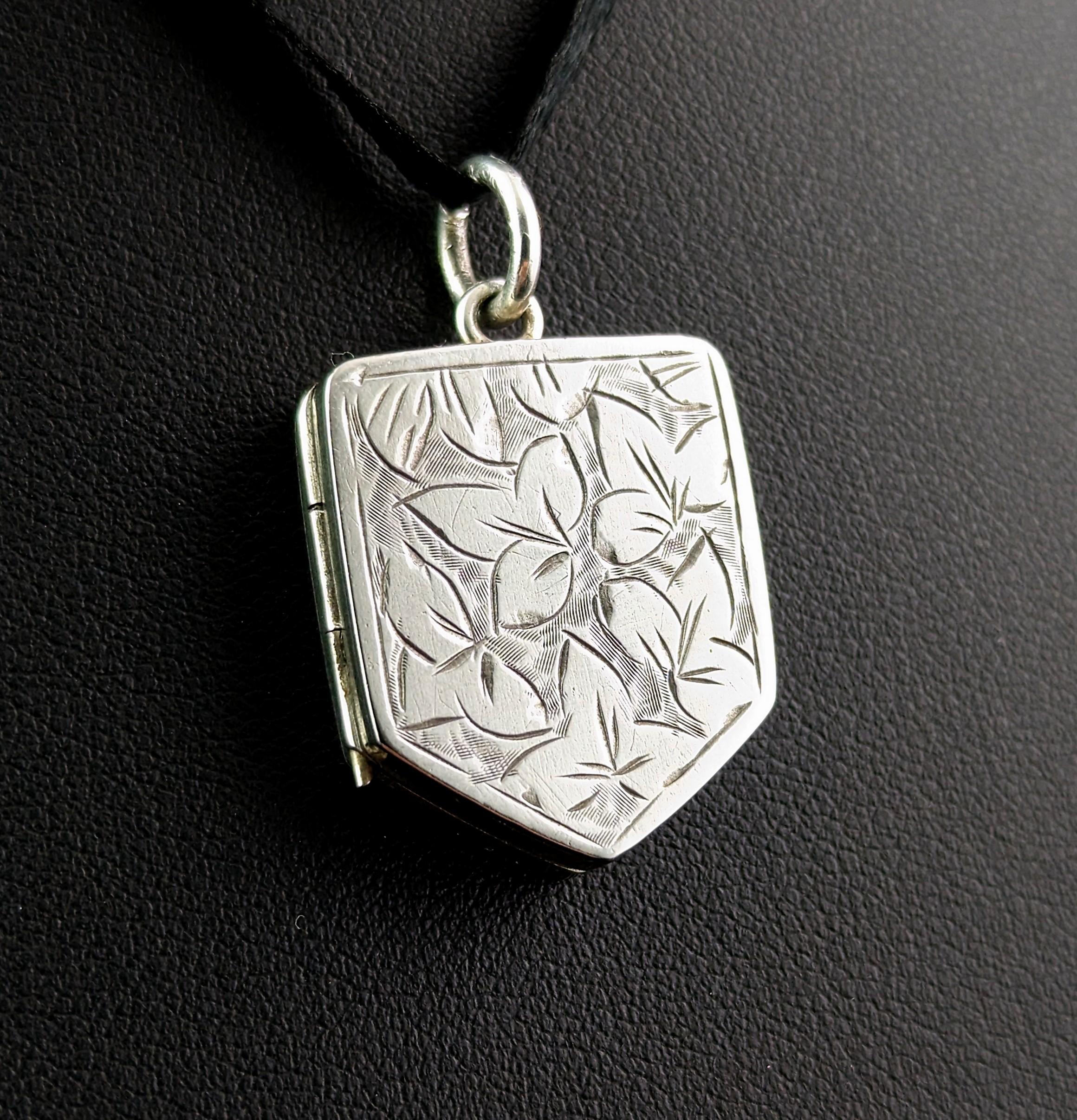 This beautiful antique Victorian sterling silver locket pendant is so decorative and unique with its attractive nature inspired design.

It is engraved to the front in the aesthetic manner with leaves and the locket is a lovely shield shape.

It has