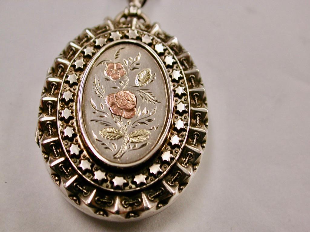 Antique Silver Locket With Applied Two Colour Goldwork On Antique Silver Chain
This exquisite silver locket was made in 1883 in Birmingham by Hardy Brothers 
The silver chain is dated circa 1880 and matches perfectly with the outside rim of the