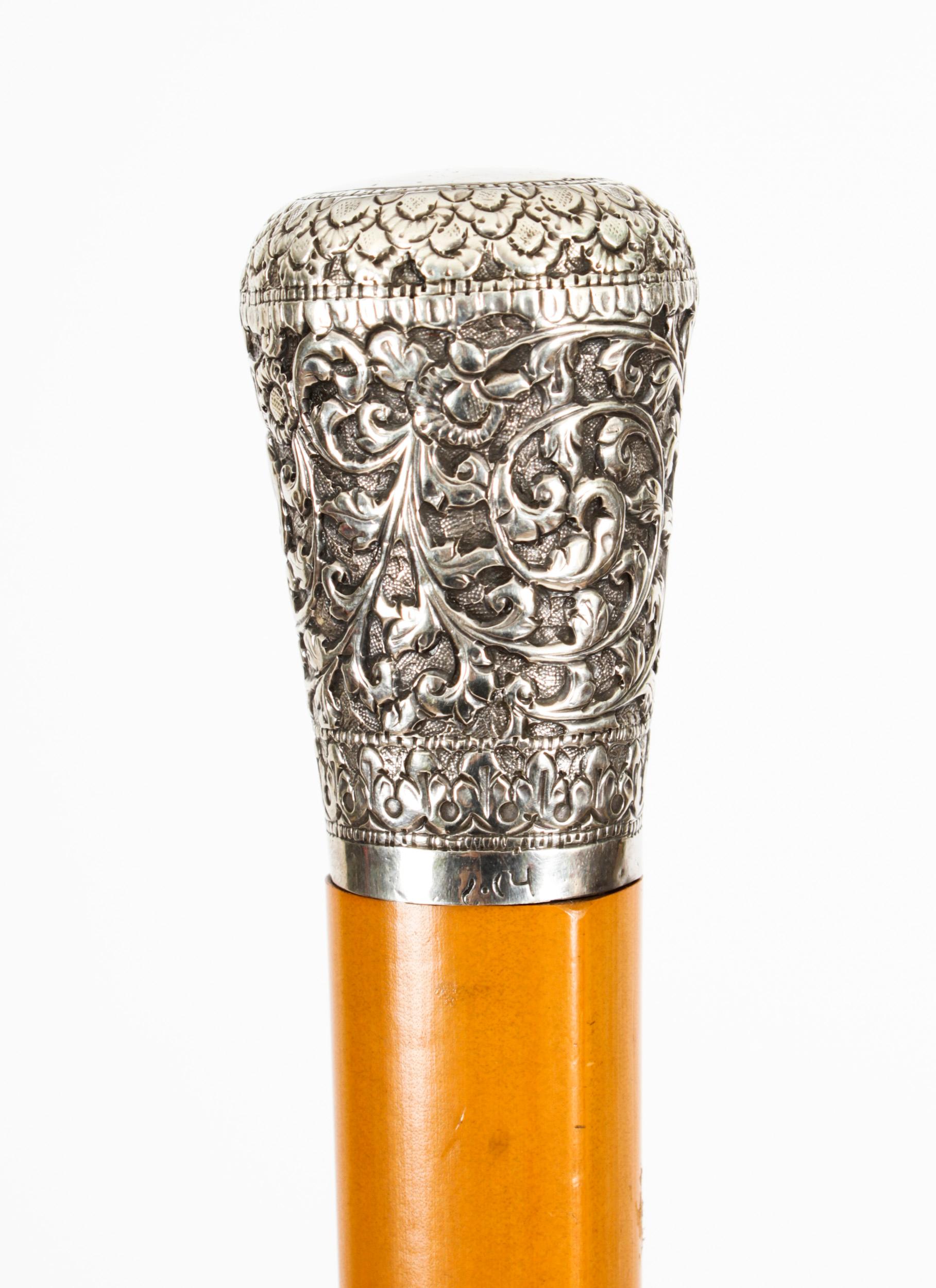 AN Indian silver handled 'system' walking cane
Late 19th century
Decorated with scrolling foliage and fitted with a corkscrew, with signature to base, above a Malacca shaft 89.4cm long
This is a beautiful antique gentleman's Indian silver pommel
