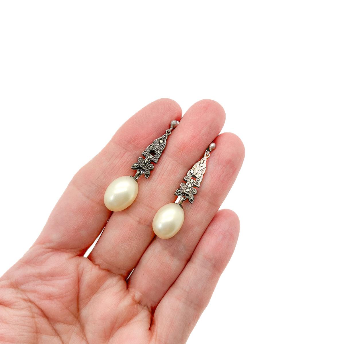 A fab pair of Antique Silver Marcasite Pearl Earrings from the 1920 era. A delightfully elegant Paris pearl drops from a marcasite set silver panel. The design heavily inspired by the Belle Epoque and the Edwardian reign married with a touch of Art