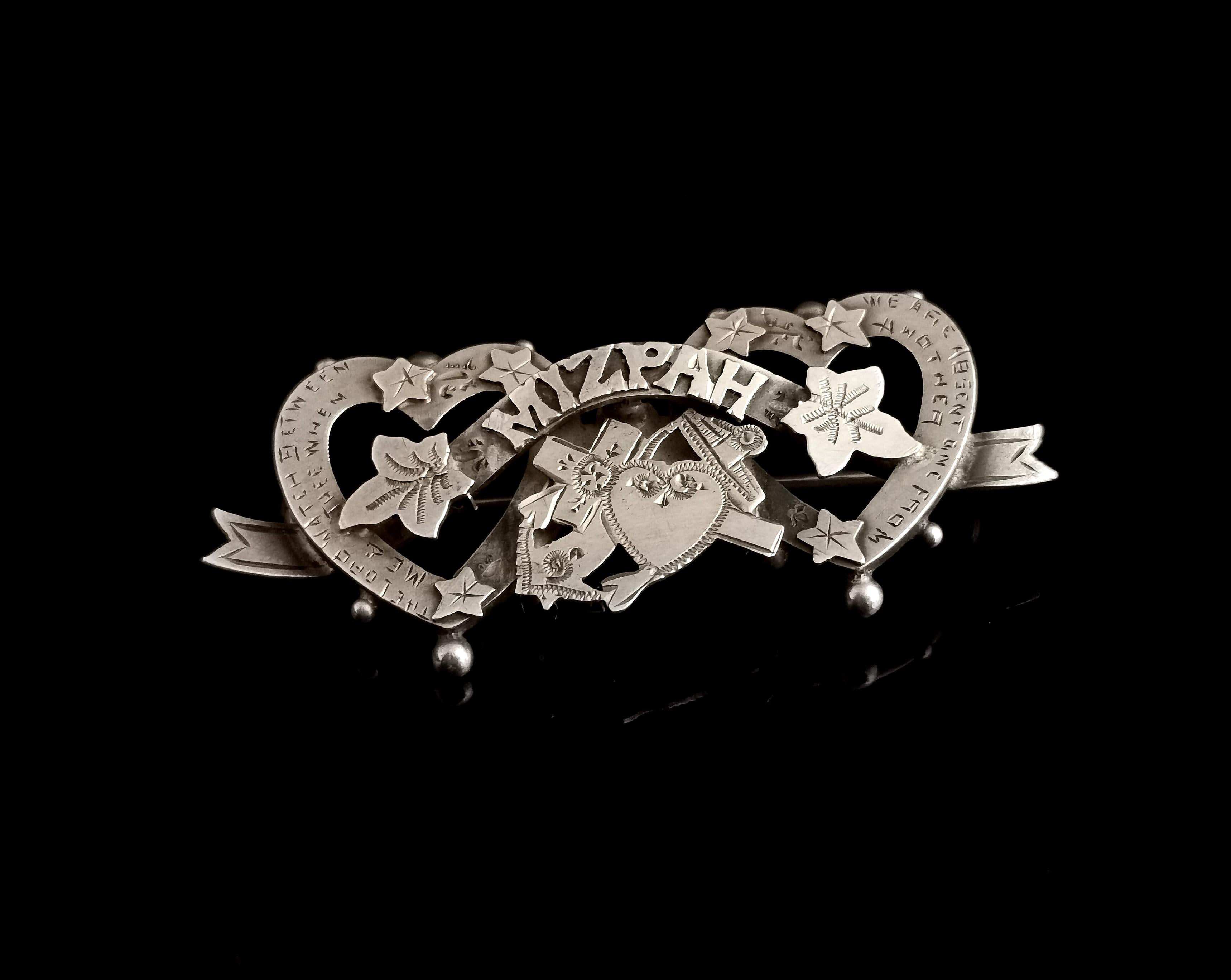 A beautiful antique, late Edwardian era sterling silver Mizpah brooch.

This brooch is so chocked full of sentiment with something new speaking out every time you look at it.

It is a double entwined heart brooch with the sentimental Mizpah to the