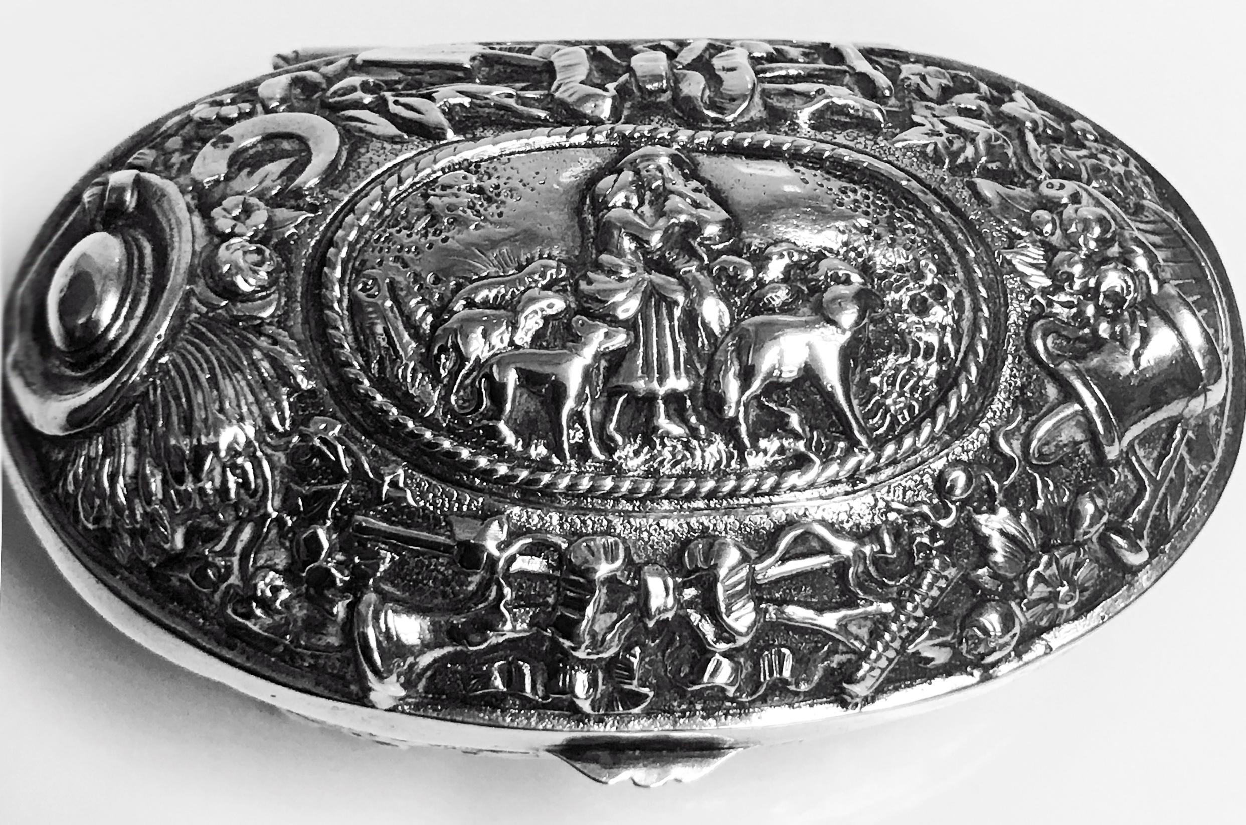 Antique silver Neresheimer Hanau pseudo marks box of oval form, with embossed pastoral farmyard scenes to the top, the lower sides with scroll and floral decoration, interior gilt. Hanau pseudo marks and retailers stamp of Ryrie of Canada to base.