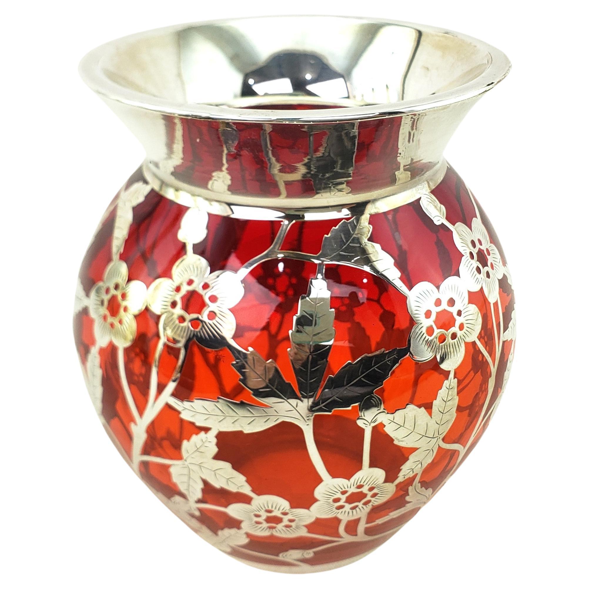 Diese gut ausgeführte antike Vase mit Silberauflage ist unsigniert, stammt aber vermutlich aus den Vereinigten Staaten und wurde um 1920 im Art-déco-Stil hergestellt. Die Vase besteht aus dickem rubinrotem Glas mit schwerem Silberüberzug, der