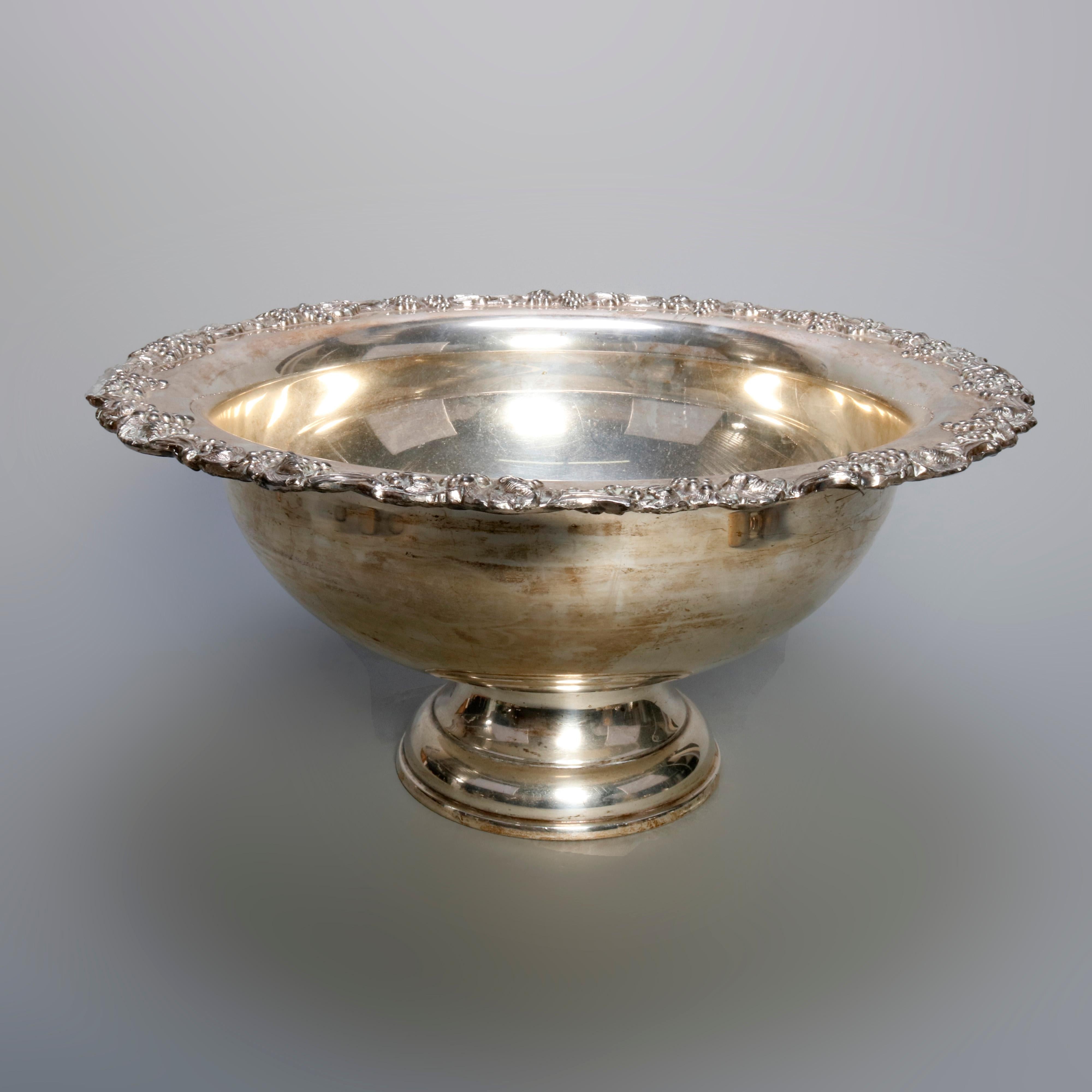 An antique silver plate punch bowl set includes bowl with grape and vine repousse bordering and pedestal base, 14 flared cups having scroll handles, and ladle, circa 1880

Measures: 9