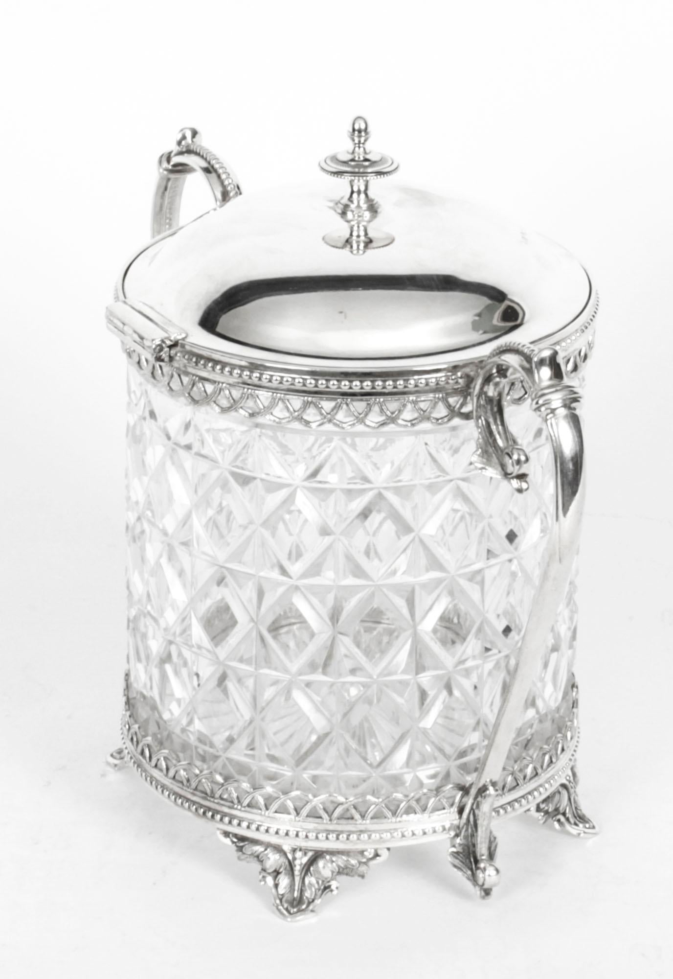 This is an exquisite cut glass and silver plate biscuit box by John Round Sheffield, dating from the late 19th Century.

The the cylindrical body features a cut glass liner with diamond cut pattern incased in a silver plated circular body with