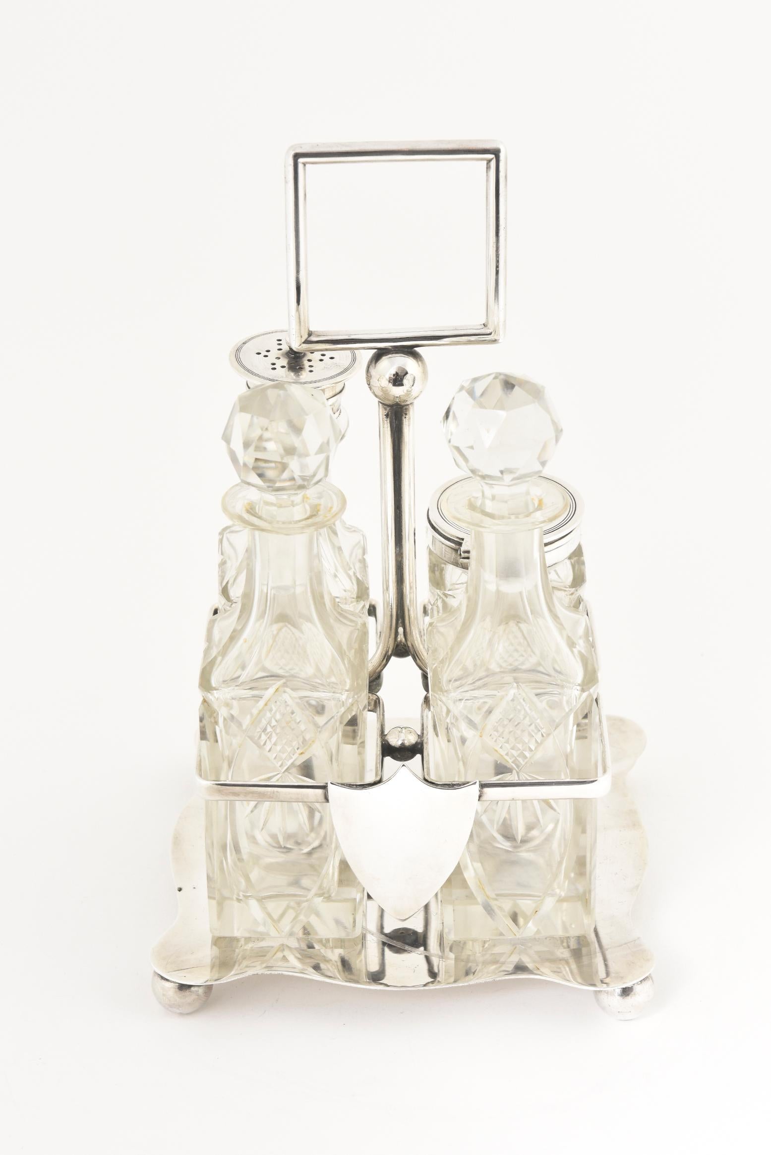 Antique silver-plate castor set with four cut-crystal bottles: shaker, oil, vinegar, and mustard or jam. The bottles are displayed in a fitted silver-plate stand with a central handle.
Includes at pair of matching bottles 1.5” x 6”
Bottle with