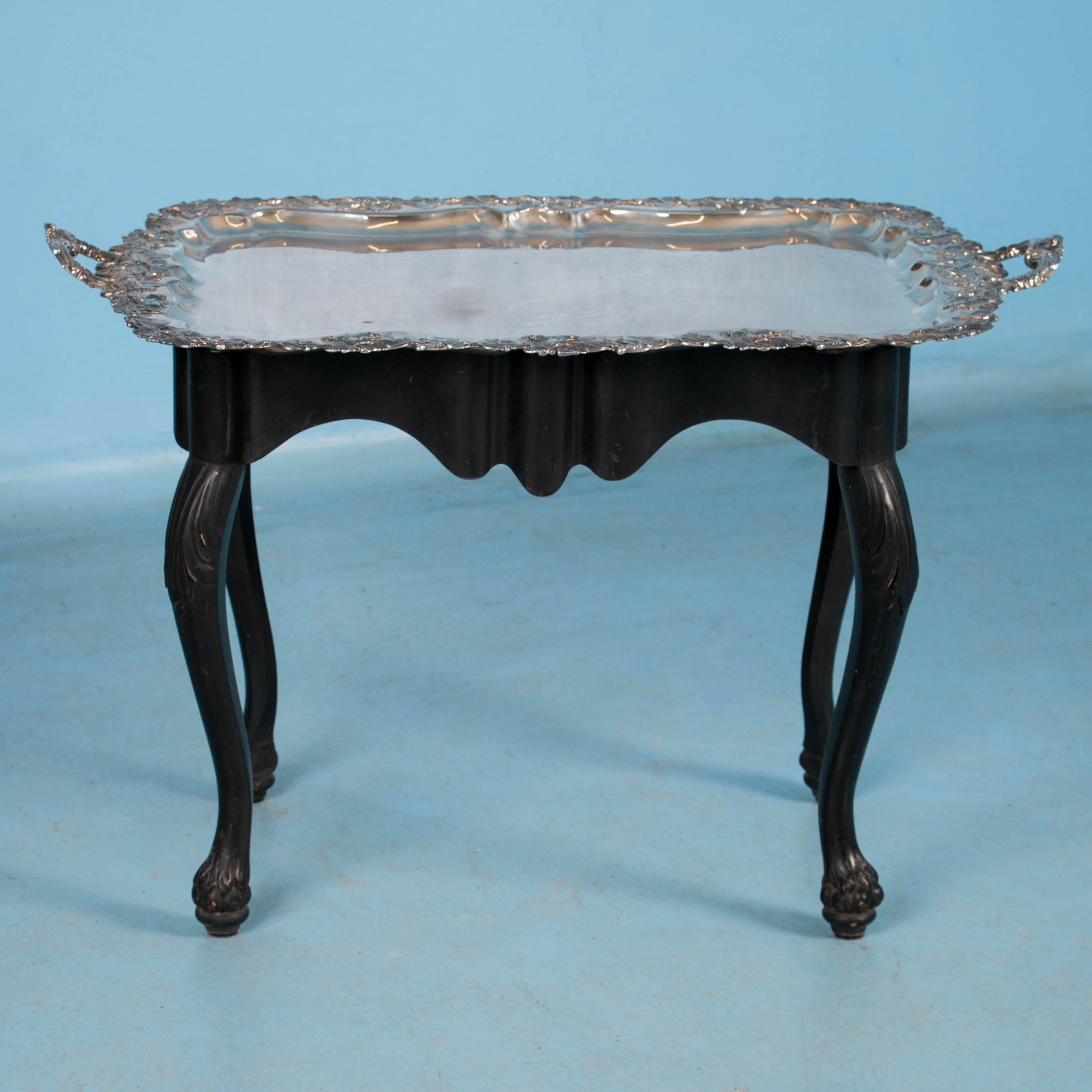 This striking side table serves as the perfect tea service table as well. The ornate silver plated tray has handles, allowing one to lift the substantial tray for serving while it also rests in place well serving as the tabletop. The cabriolet legs