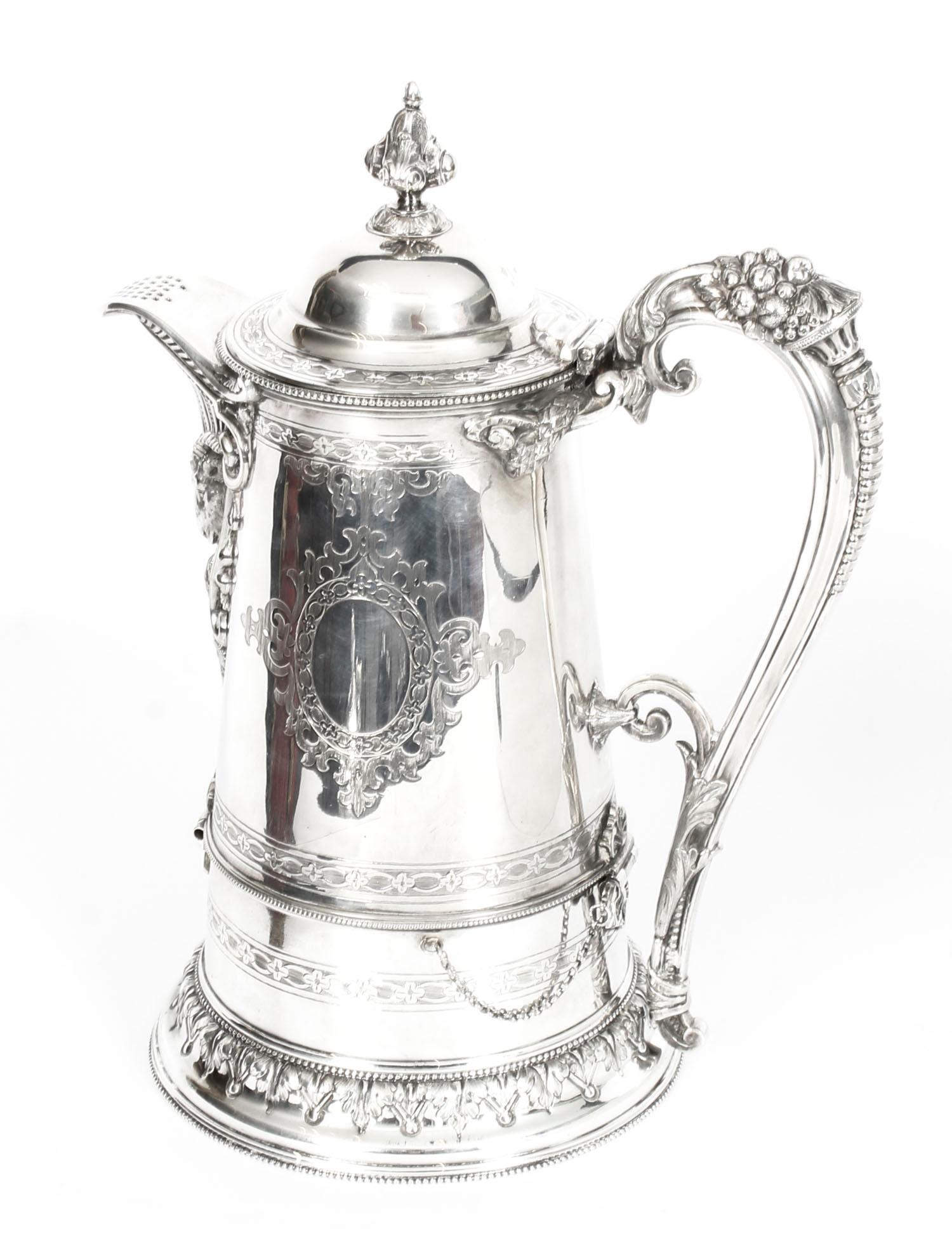 This is a wonderful antique English Victorian silver plated flagon by John Round of Tudor Street Sheffield, England, circa 1875 in date.

It has superb embossed and engraved decoration, with a decorative ram's head spout, a handle with grape