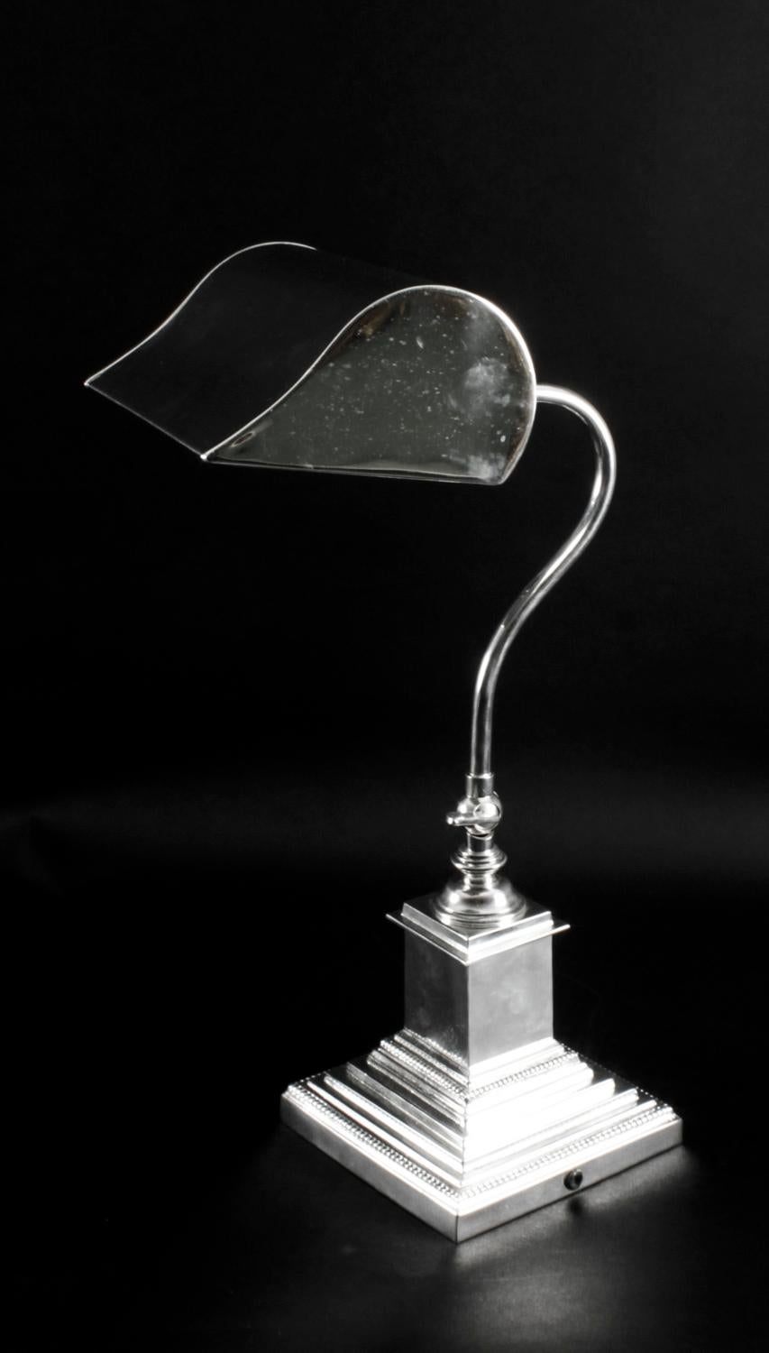 This is a truly superb antique silver plated bankers lamp, circa 1920 in date.

It is silver plated on brass, has an adjustable stem and is raised on a stepped square Corinthian style base.
 
The craftsmanship is second to none throughout all