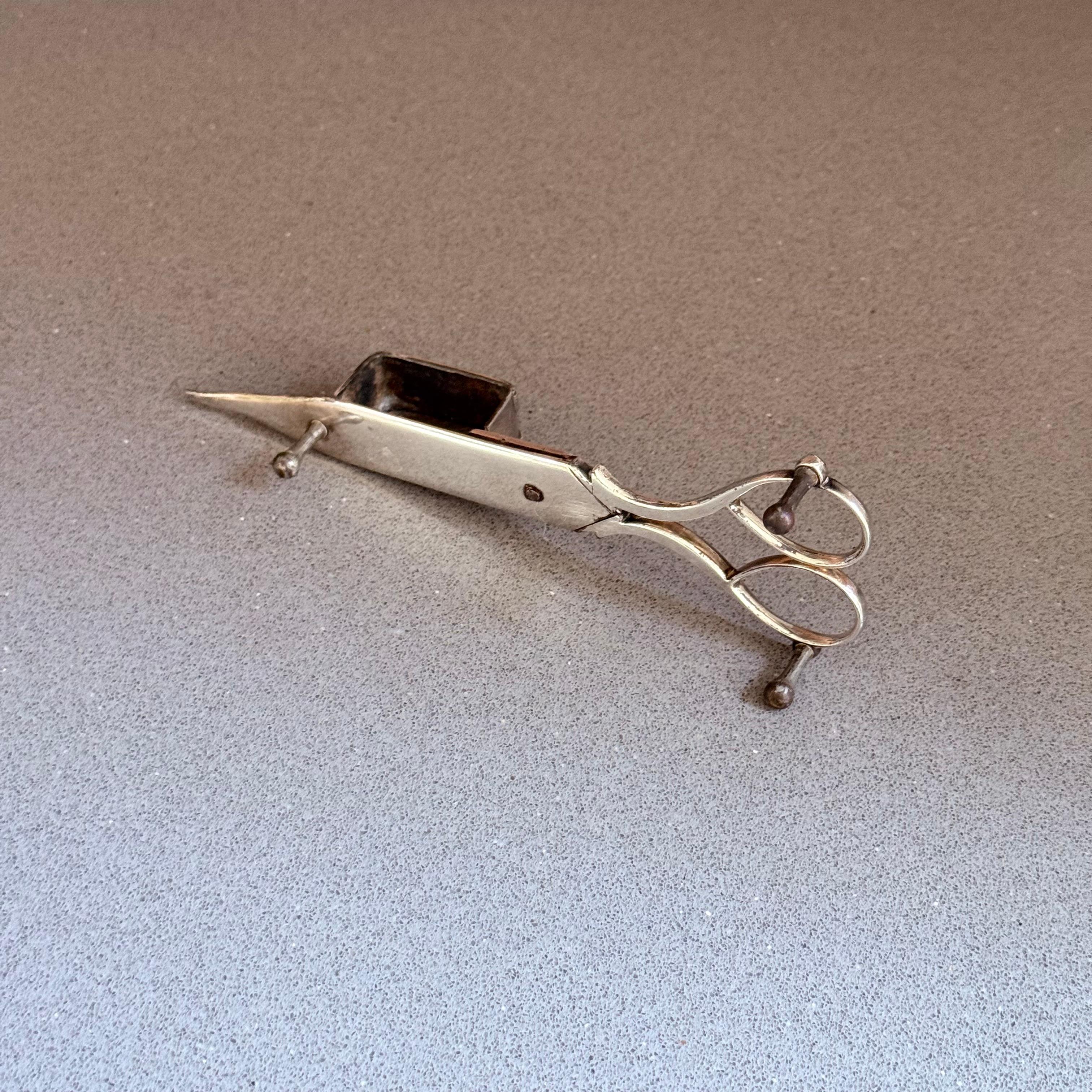 Antike versilberte Kerzendochtschneider-Schere, viktorianische Tischdekoration
Ein exquisiter, antiker, versilberter Kerzendochtrimmer, der elegante viktorianische Handwerkskunst und zeitlose Schönheit zeigt. Diese seltene Schere zeichnet sich durch