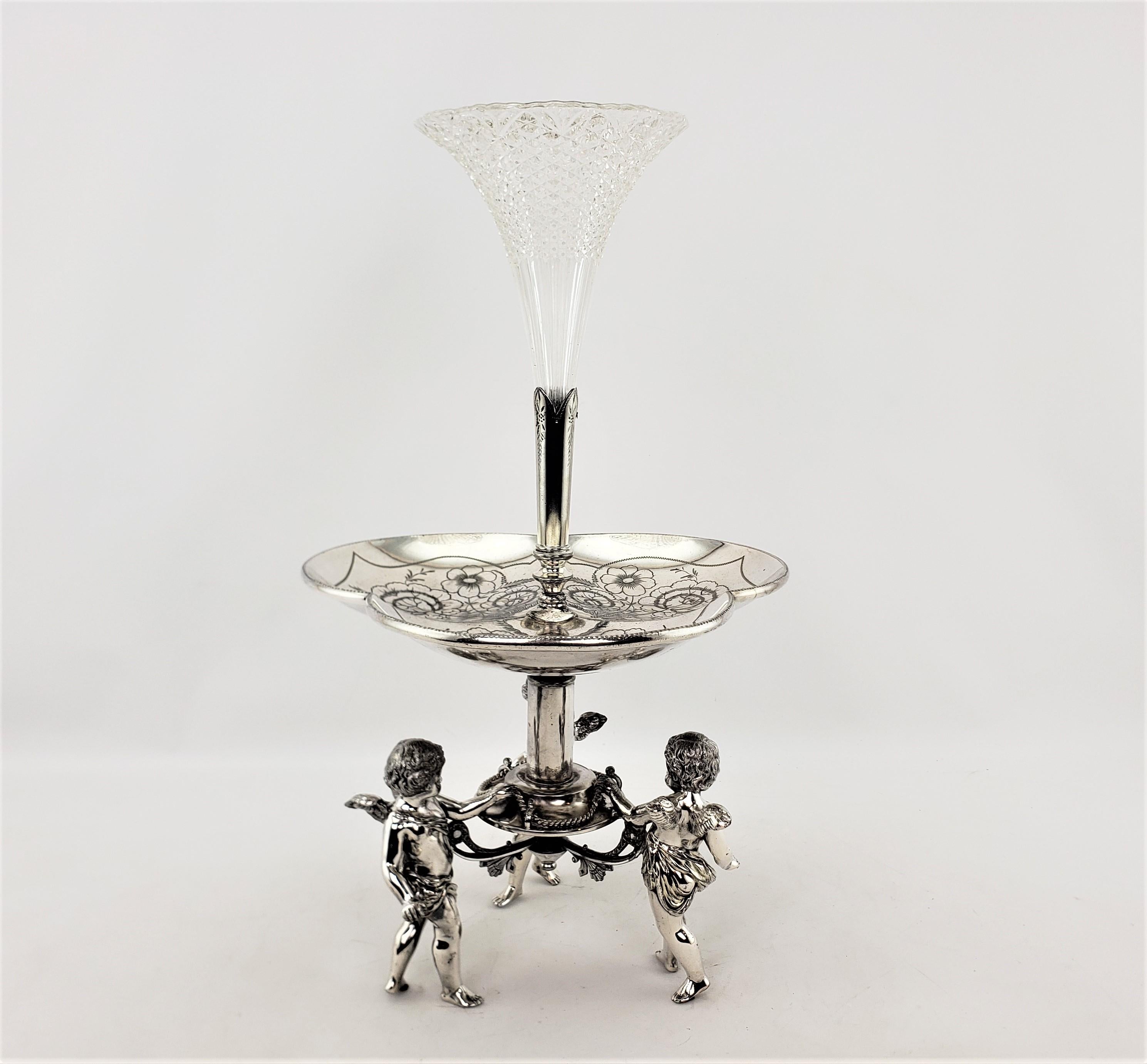 This large centerpiece or epergne was made by the well known Wilcox Silver Plate Company of the United States in approximately 1900 and done in a Victorian style. The base is composed of silver plate and features three figural children holding a