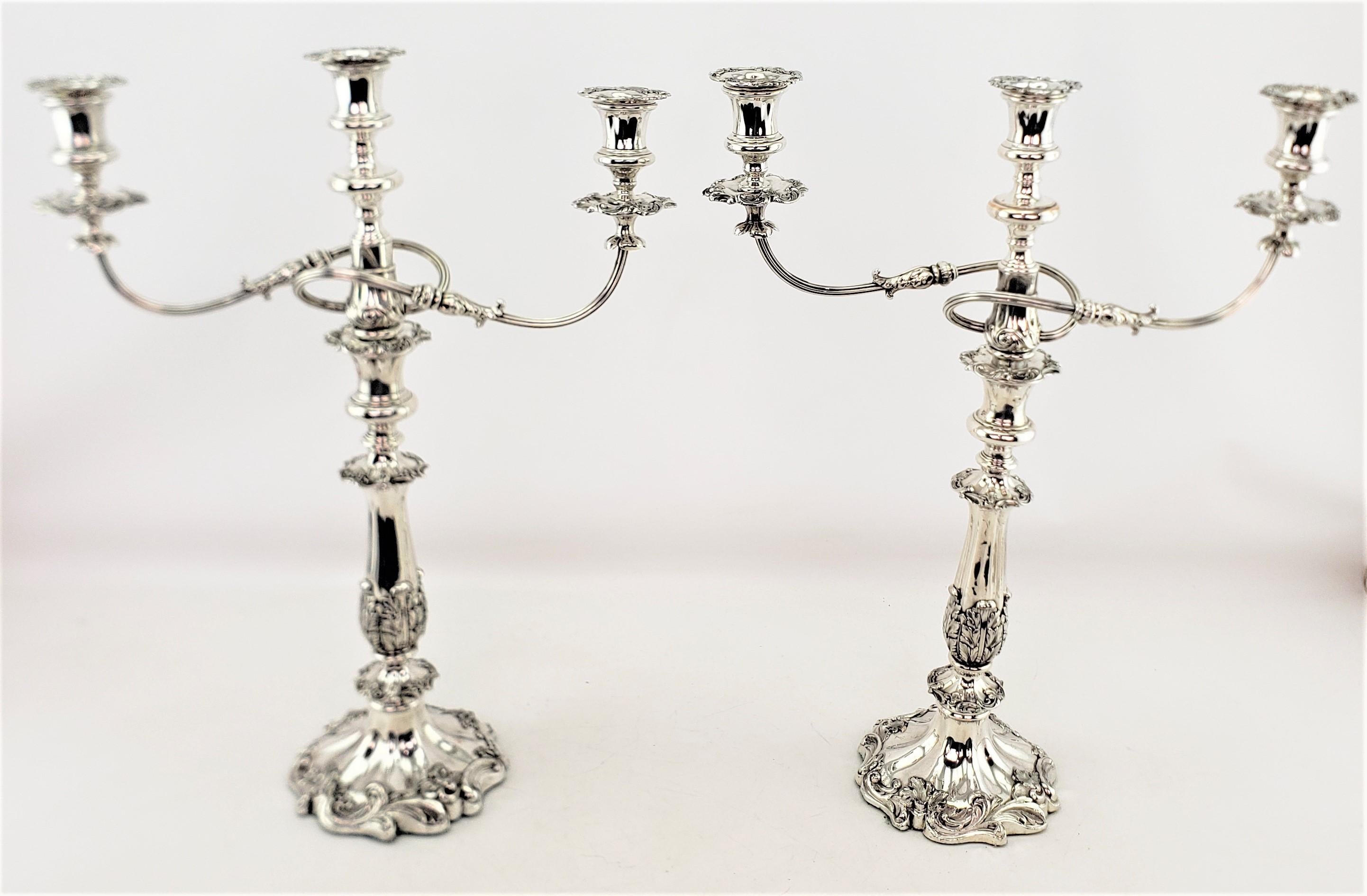 This pair of antique candelabras are unsigned, but presumed to have originated from England and date to approximately 1880 and done in the period Victorian style. These candelabras are composed of silver plate with a three cup insert, which can be