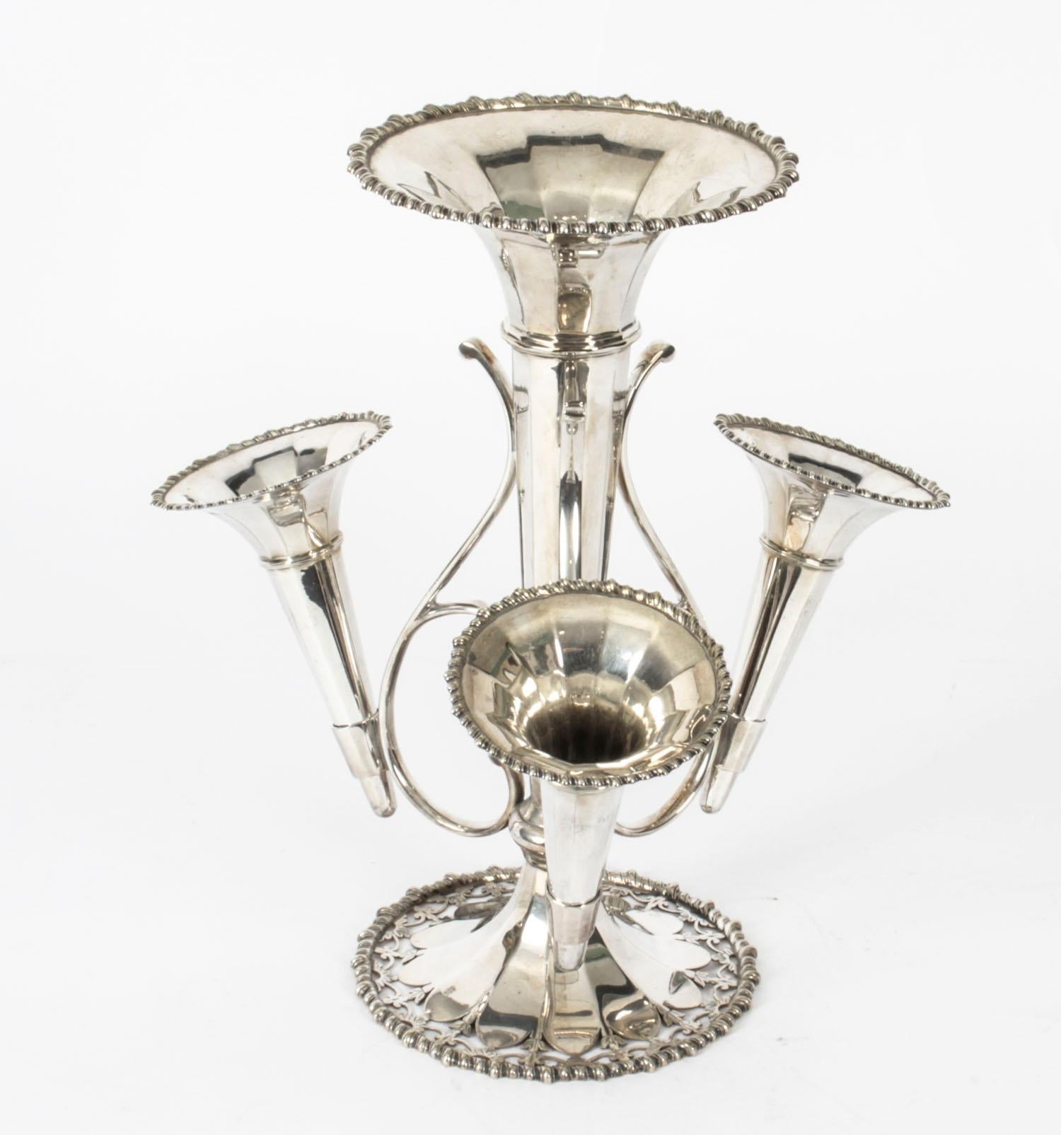 This is an attractive silver plated Victorian epergne by Daniel & Arter of Birmingham, England, Circa 1890 in date.

The central vase surrounded by three further smaller vases and raised on a central stem.

The underside bearing the impressed