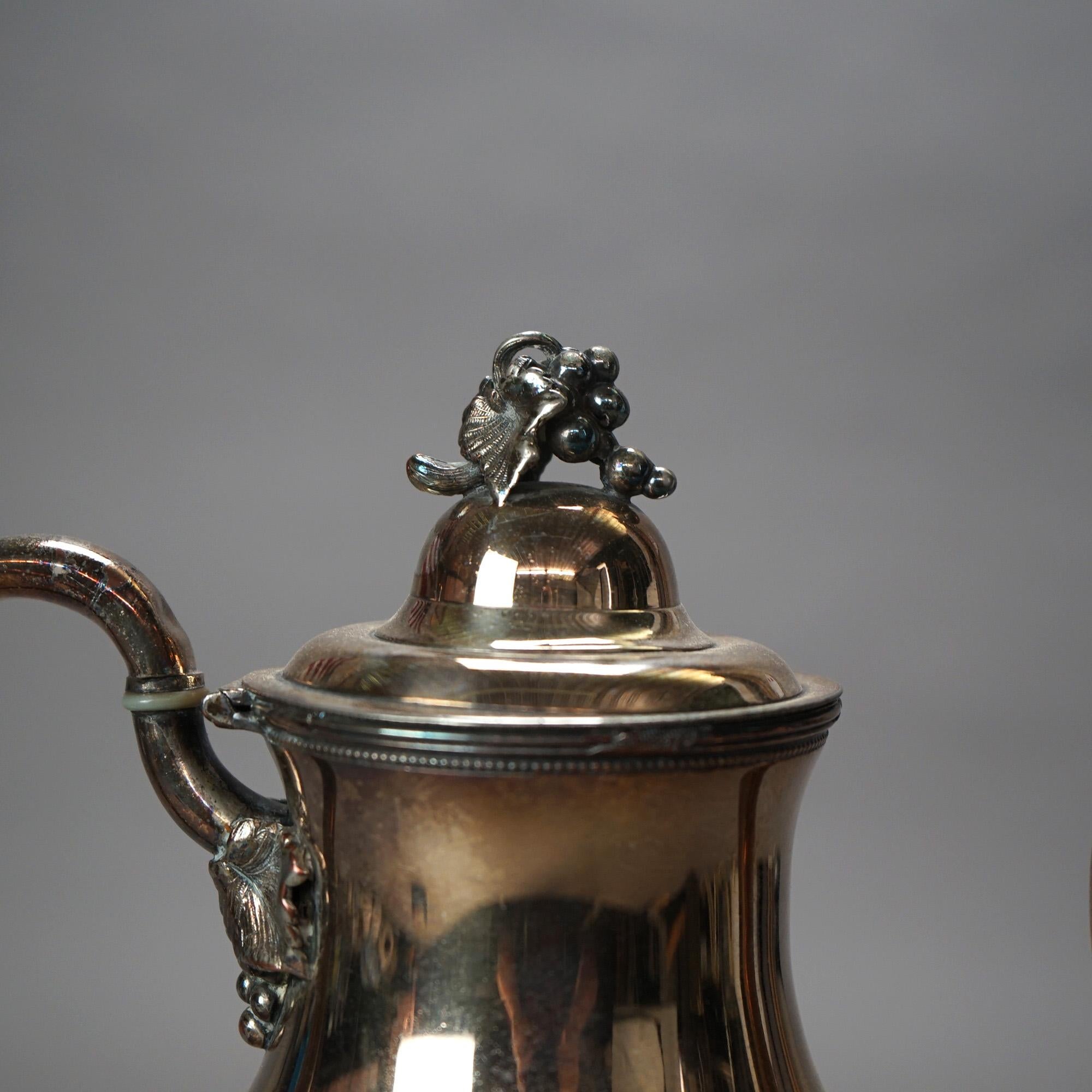 Théière ancienne en argent plaqué avec gravure de fruits et masque C1890

Dimensions - 12 