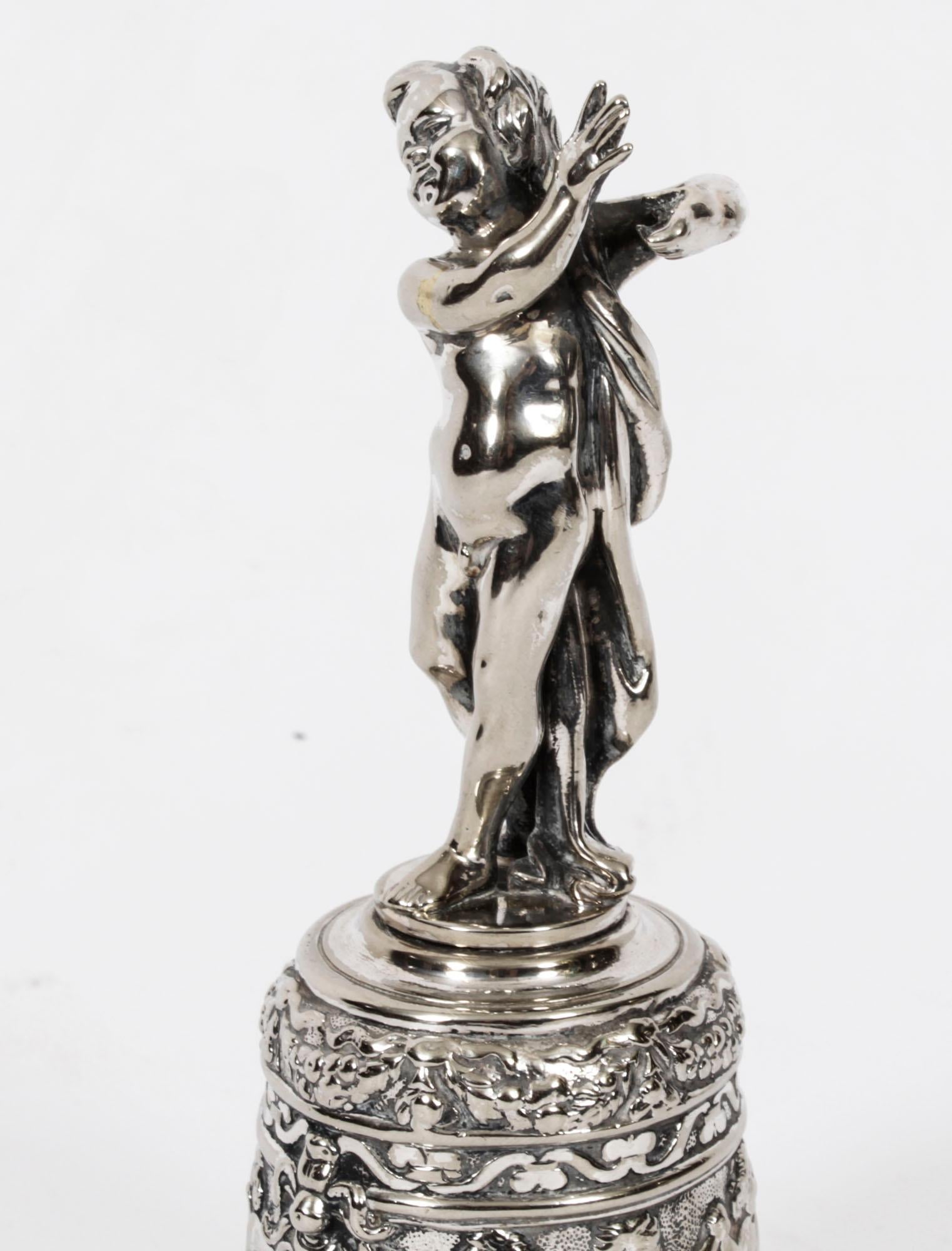 Antique Silver Plated  Renaissance Revival  Hand Bell by the renowned silversmith and retailer, Elkington & Co, late 19th Century in date.

The heavy cast bell surmounted with a cherub figure, the bell further worked with dancing cherubs. 
This bell