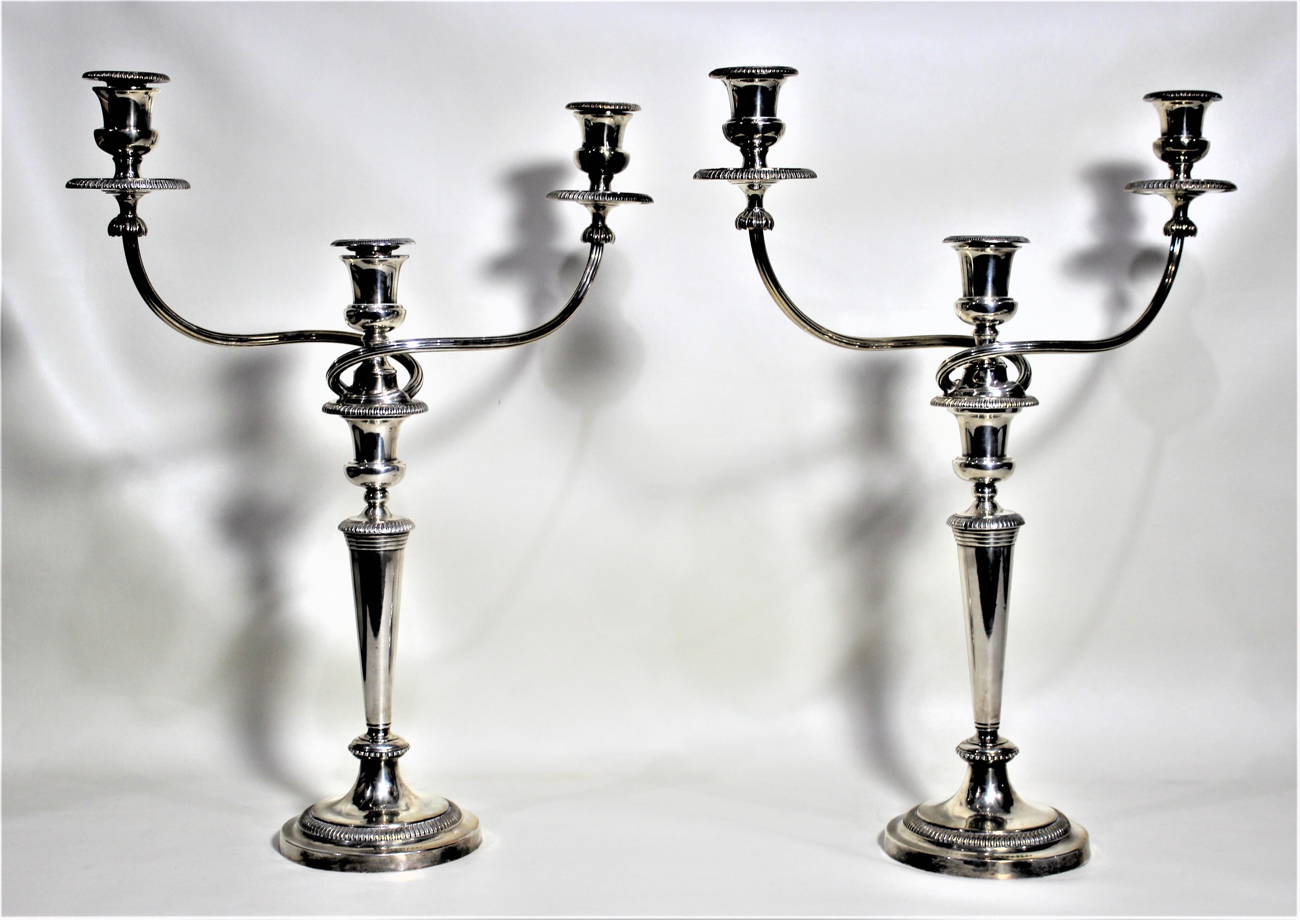 Dating from the mid-19th century, this pair of silver plated candelabras were made by the renowned silversmith, Mathew Bolton of Sheffield England. As presented in the photos, this set is convertible from impressive three branch candelabras to