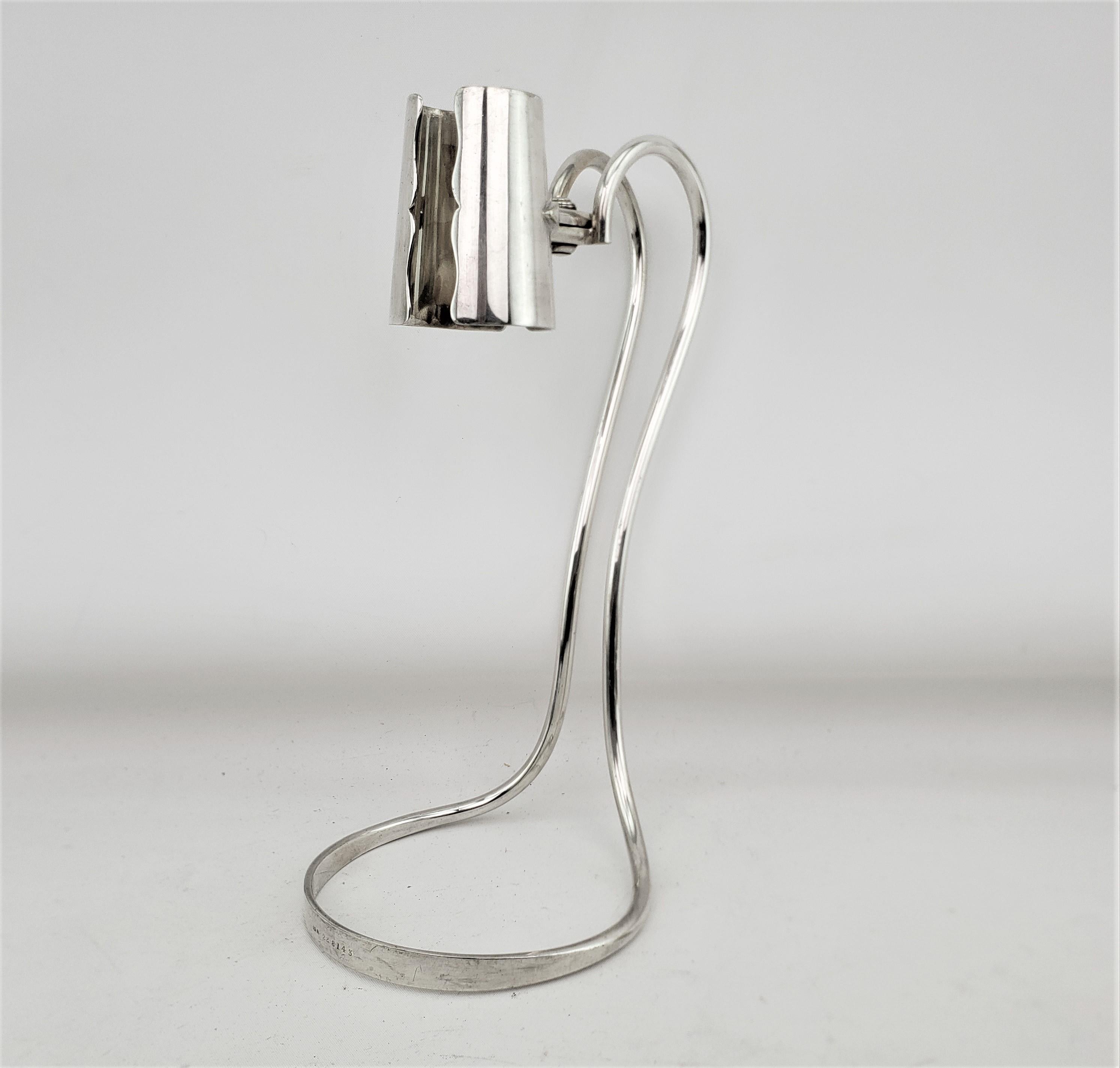 This antique bottle holder was made by the well known Hukin & Heath silversmiths of England and dates to approximately 1920 and done in the period Art Deco style. The well constructed bottle holder is composed of silver plate and is clearly