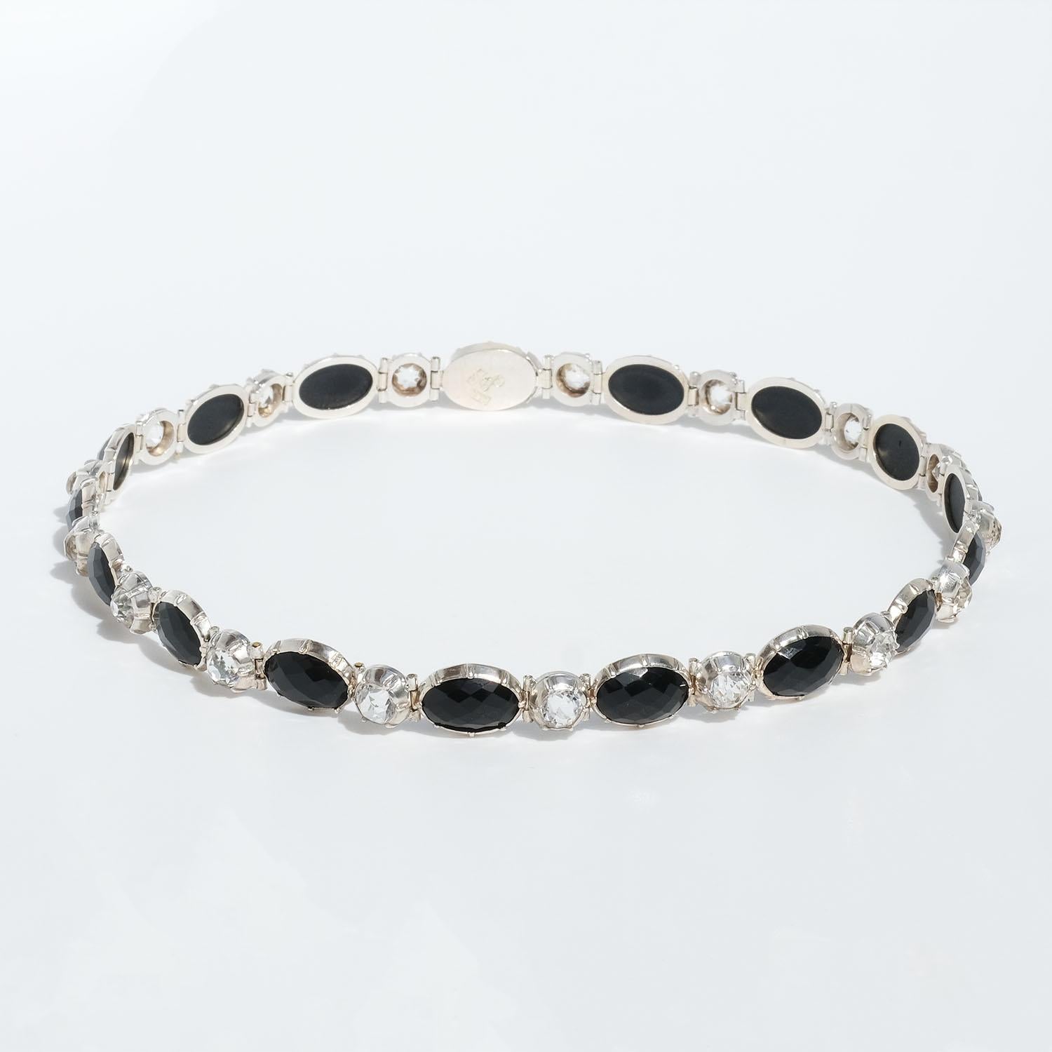 This sterling silver choker necklace is adorned with oval onyx stones and round rock crystals which are placed together with small hinges. The necklace closes easily with a clasp box.

It is made by the Swedish Master Carl Johan Häggström I the year