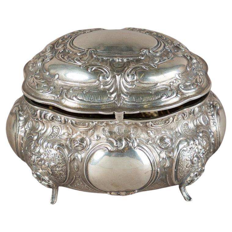 Antigua y valiosa caja de plata o Azucarero decorativo con tapa prensada, fundida y cincelada, dorada en el interior. Cuerpo ovalado y abovedado sobre pies cortos y curvos, con tapa abovedada articulada. Curvas en C en relieve, celosías, rocallas,