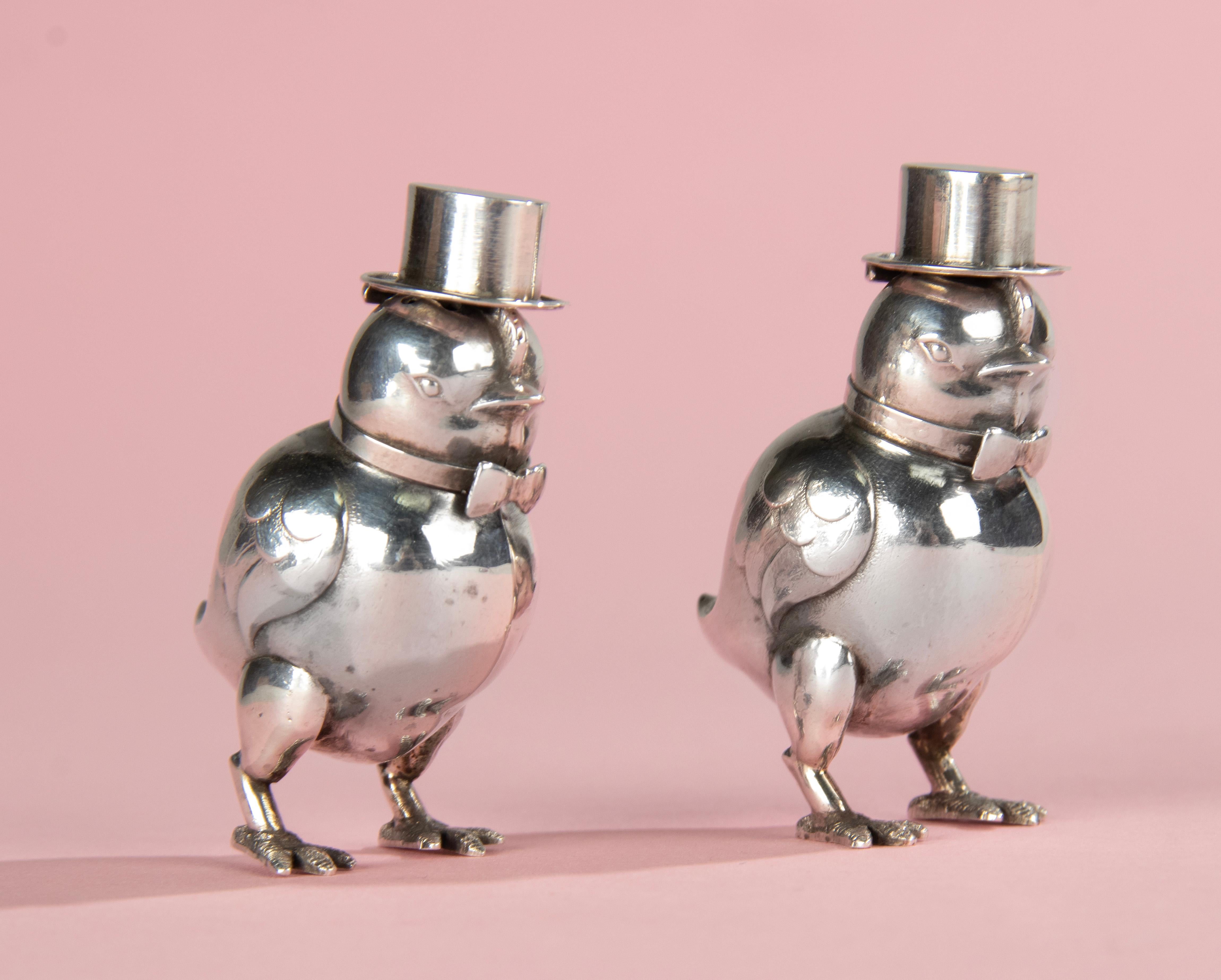 A sweet salt and pepper set, shaped like little birds with hats and bows, made of solid silver.
The set is made with great attention to detail, very refined.
Both pieces are marked, on the bow and on the feet. But the mark is so small that it is