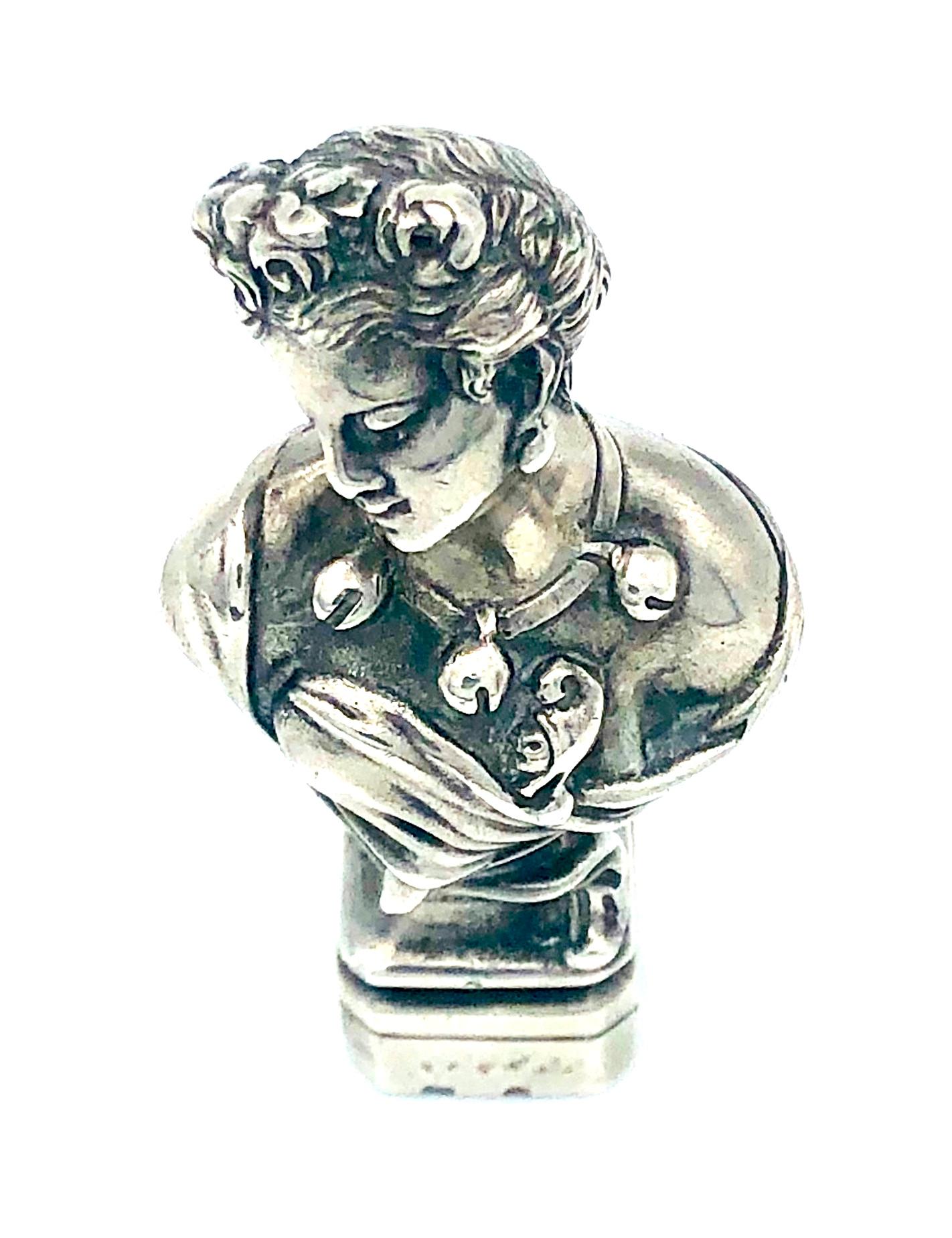 This unusual desktop seal in the shape of a beautiful yong lady wearing roses in her swept up coiffure. She is dressed in a low cut dress and wears an important necklace. 