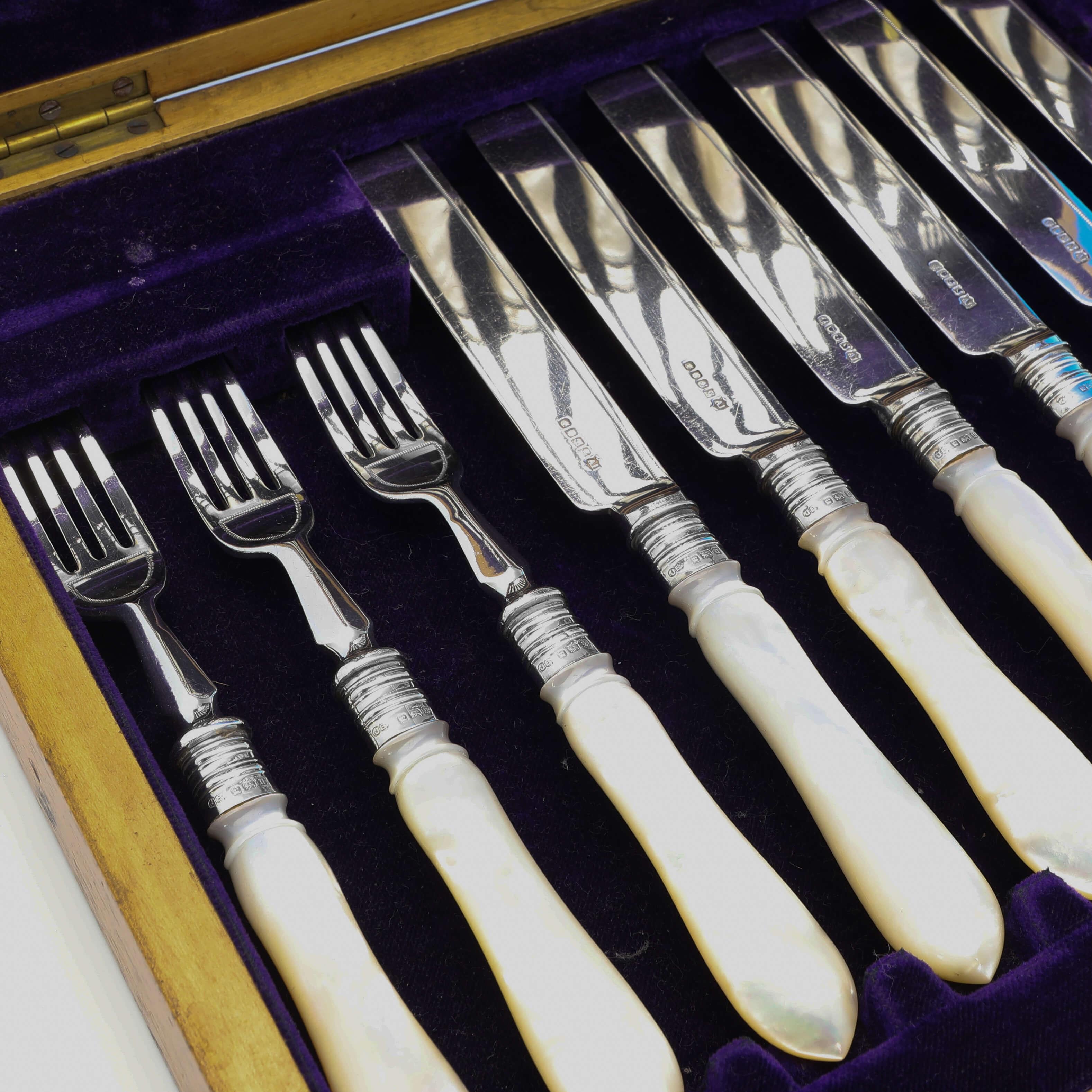 Made in Sheffield in 1912 by John Biggin, this stylish, Antique Silver Plated Dessert Set, comprises 12 knives and 12 forks with baluster shaped mother of pearl handles and hallmarked sterling silver collars. 

Each knife measures 8.25