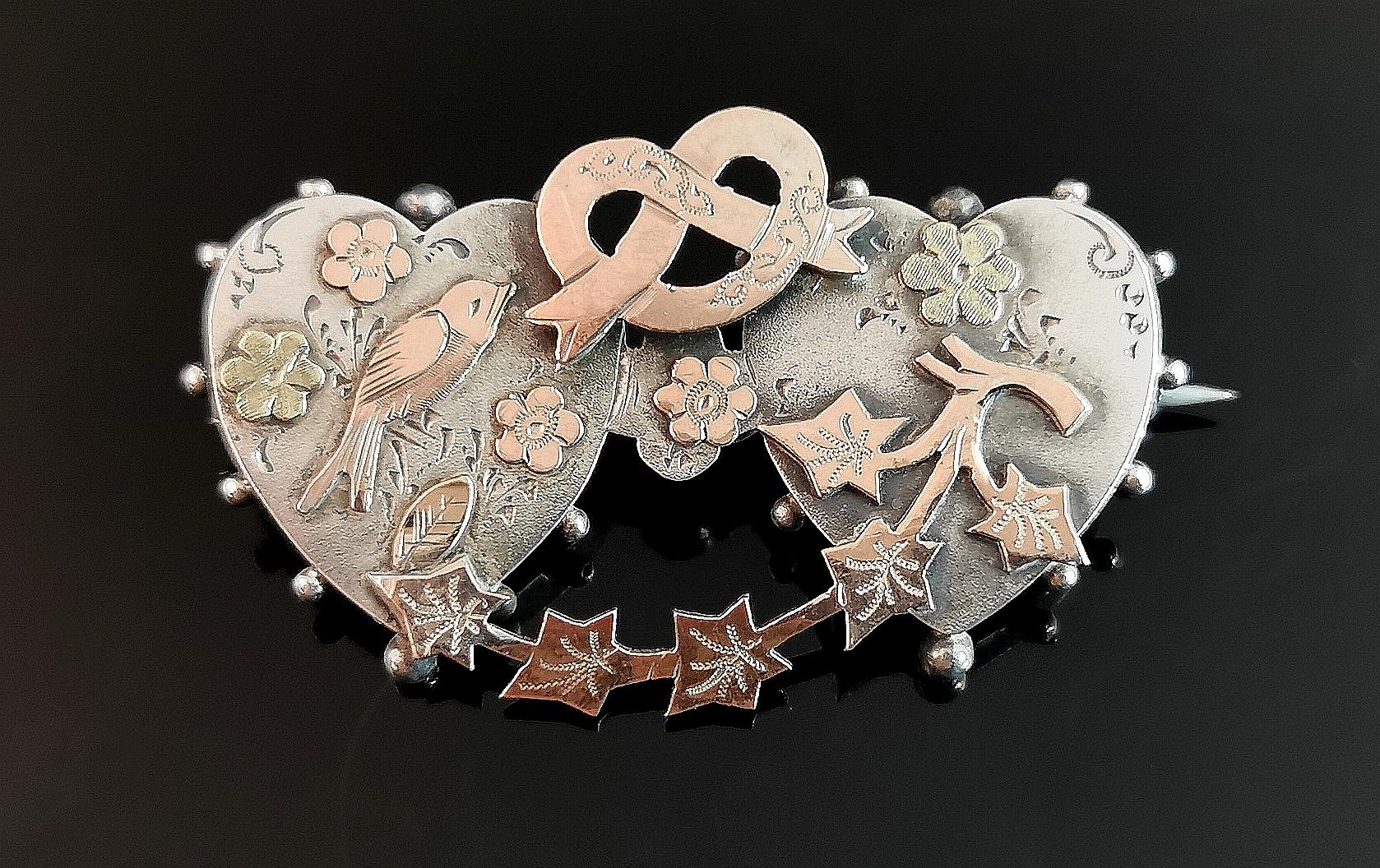 An attractive and unusual antique sweetheart brooch.

This particular sweetheart brooch really does pack in every kind of symbolic message it can.

Crafted in sterling silver, it has applied yellow and Rose gold accents.

The brooch is made up of