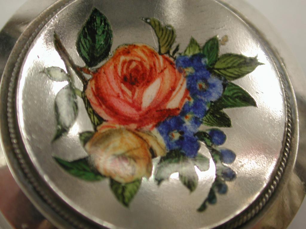 Antique Silver Target Brooch with Flower Enamelled Front,  dated circa 1880
Beautifully hand painted enamel with a locket back for either hair or photo.
