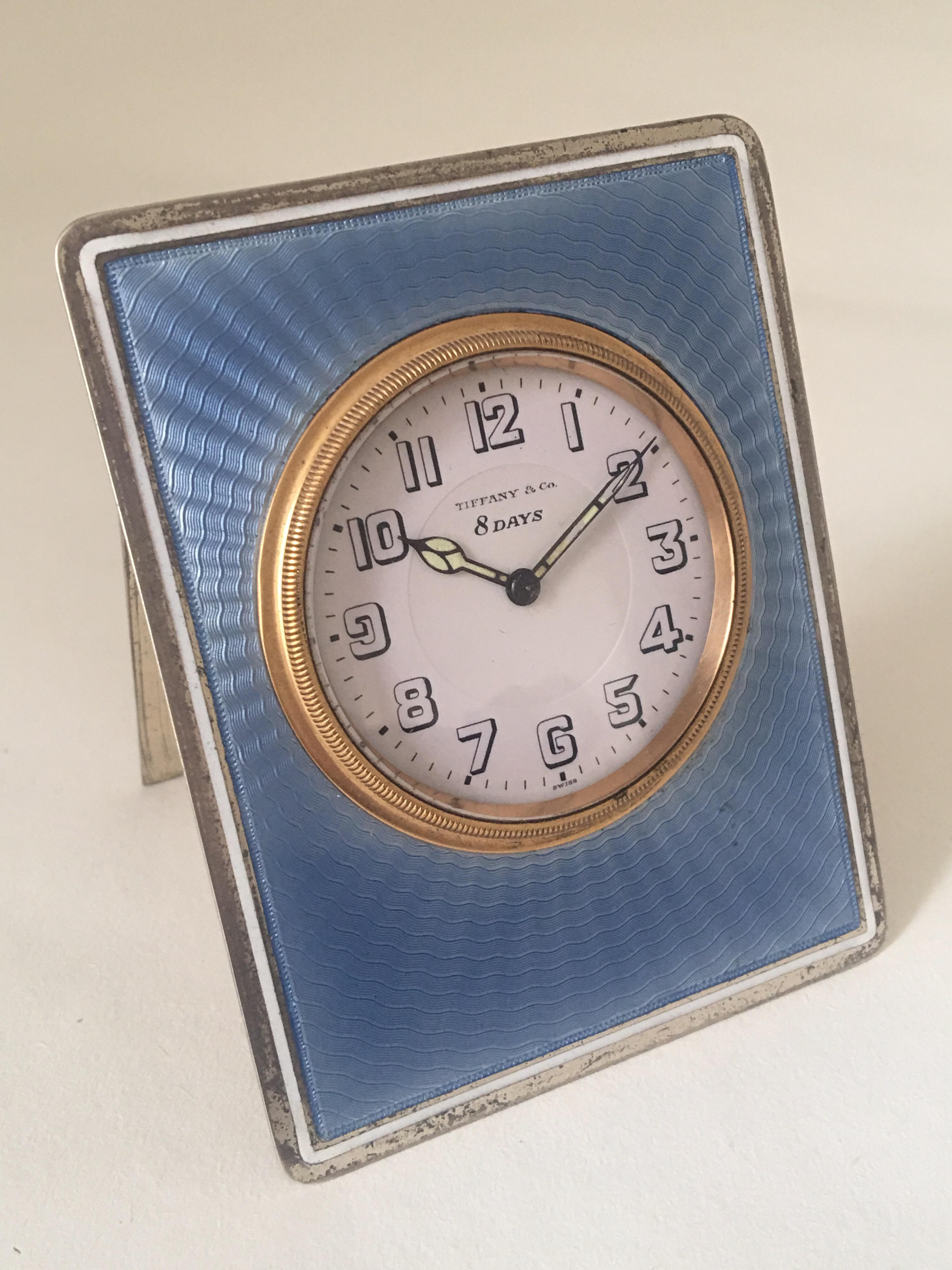 An early 20th century American silver and guilloche enamel desk clock signed 'Tiffany & Co.' of strut form with an easel support to the reverse signed 'TIFFANY & CO STERLING HAND WROUGHT', with gilt bezel enclosing the Arabic dial signed 'Tiffany &