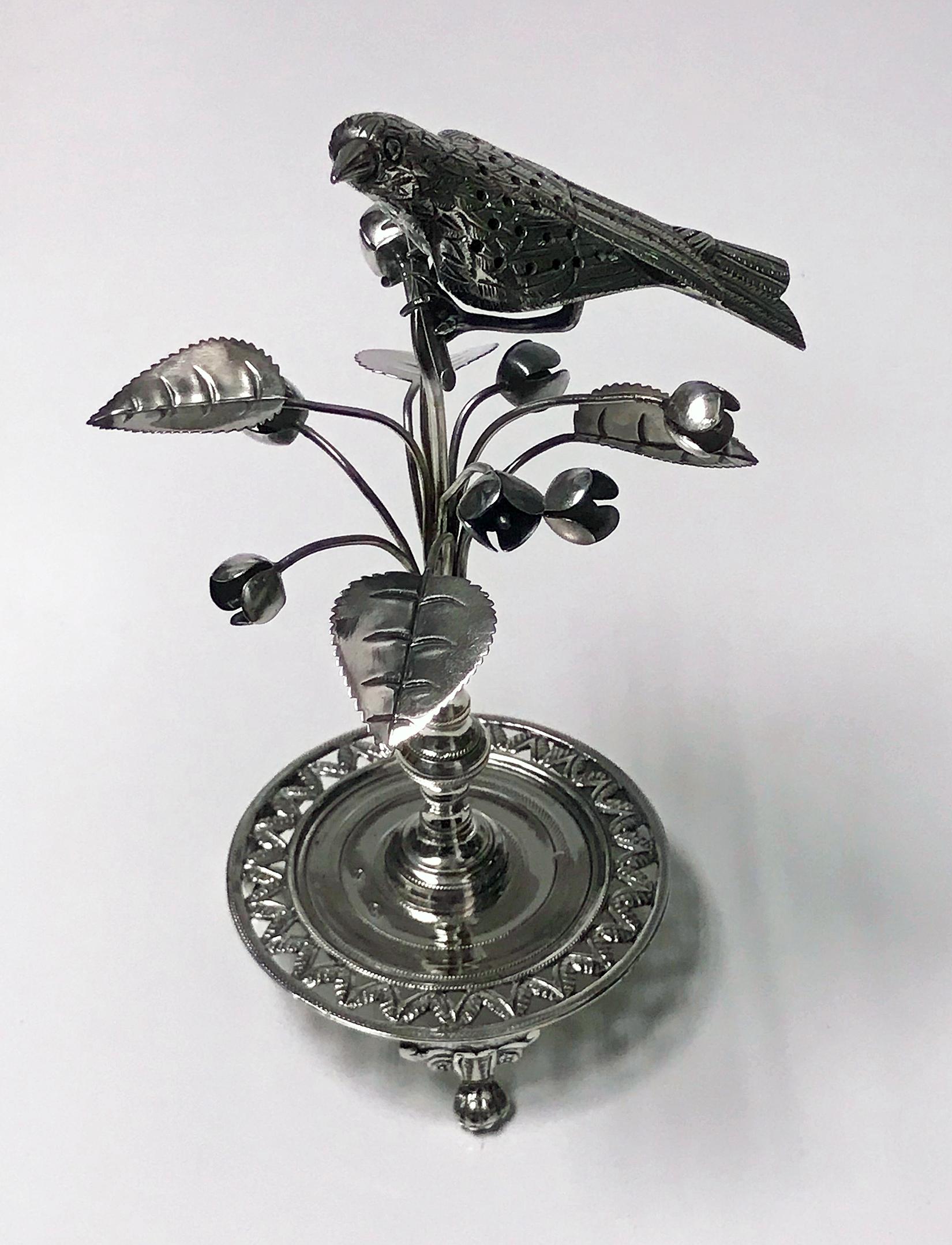 Antique silver toothpick holder, Rio de Janeiro, Brazil, circa 1850. The holder in the form of an exotic bird surmounted on bud flower foliage branches on knopped stem in turn on circular pierced foliage and wriggle work base on three turned knuckle