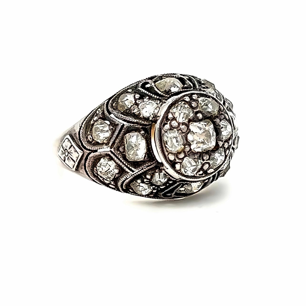 This Antique Silver topped Gold Diamond Ring Engagement Ring is a beautiful example of antique design and craftsmanship. Also super sparkly! Crafted in 8K Yellow Gold, and topped in Silver, this ring features amazingly detailed openwork with Pave