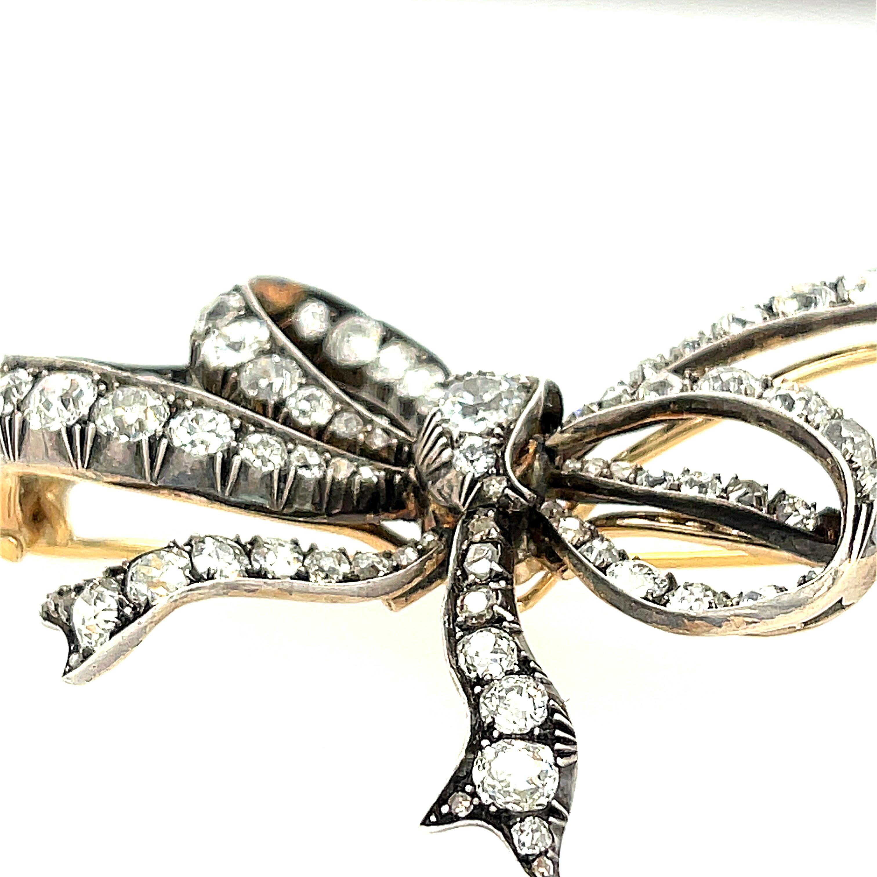 Antique late Victorian diamond and silver topped gold bow brooch, circa 1890. This brooch is wonderfully dimensional and feminine. It is set with 97 Old mine cut diamonds and some rose cut diamonds. There are about 5.50 carats total in the brooch.