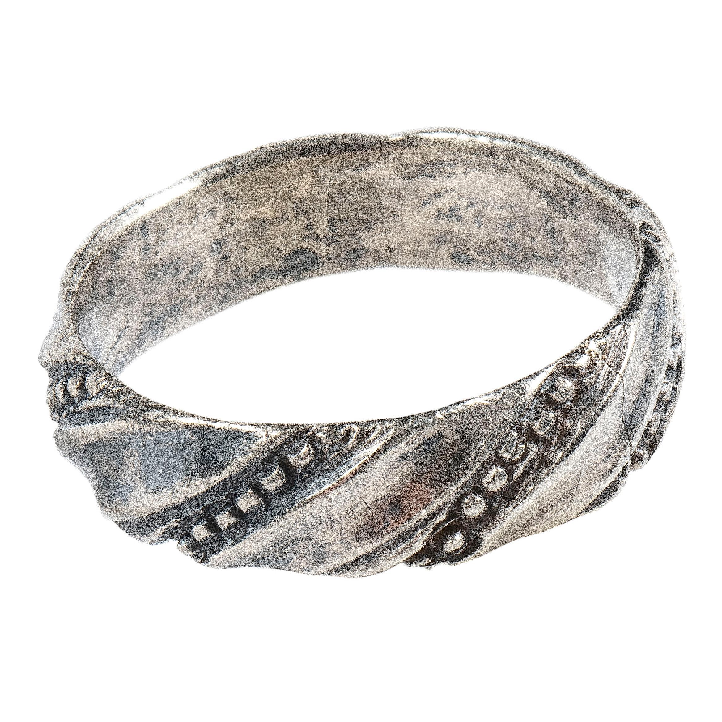 Twisted Band Ring  
Silver  
England, 15th-16th century  
Weight 2.9 gr.; circumference 51.9 mm.; US size 6, UK size M  

The wide silver hoop is slightly rounded inside with an original solder point and twisted and beaded on the outer side. Between
