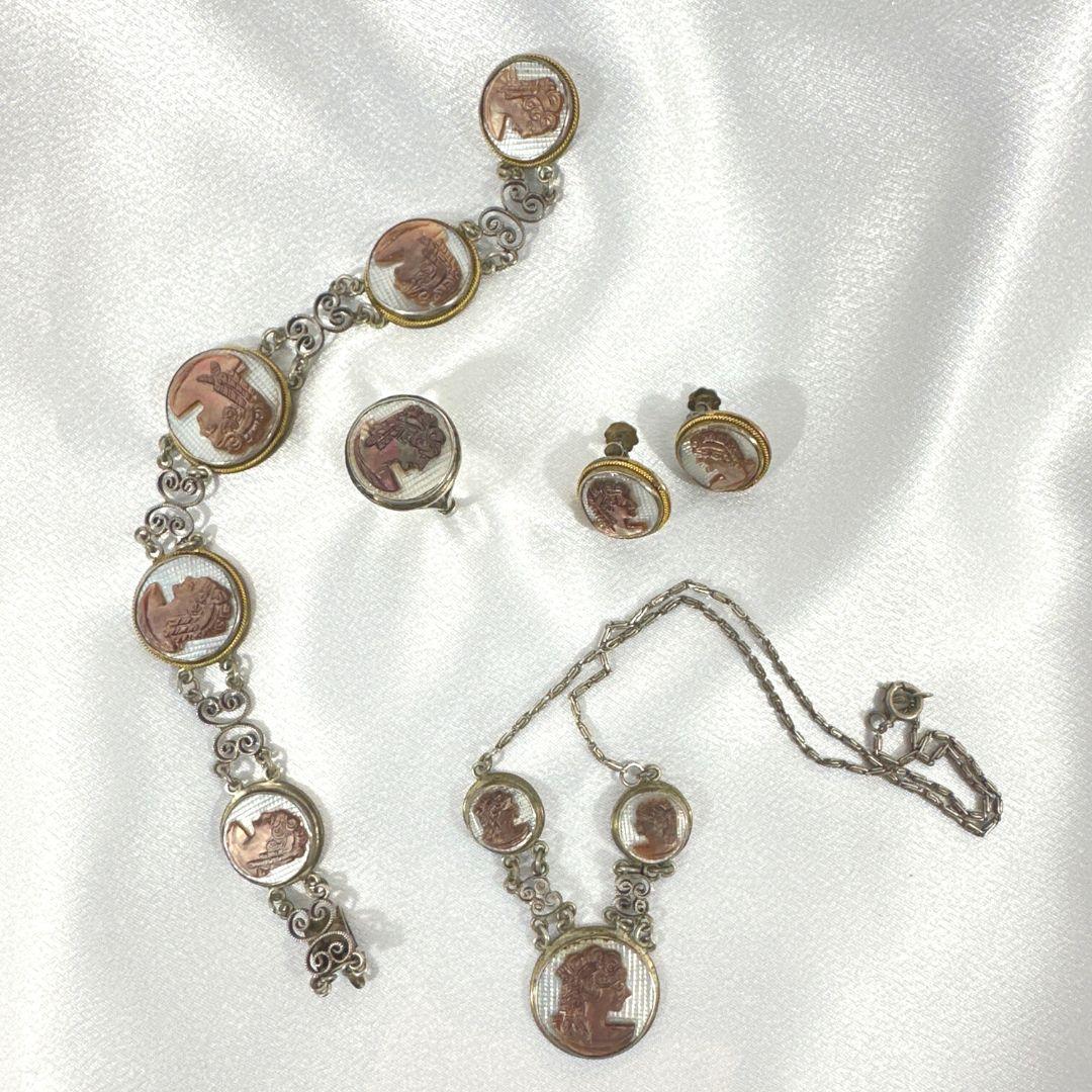 Ring size: 6.5
Earring diameter:0.57
Necklace length: 15.25″
Bracelet length: 8″
Bin Code M25 / P15
Indulge in the enchanting allure of early Victorian elegance with this Antique Sterling Silver Artemis Cameo Set. This exquisite set features a