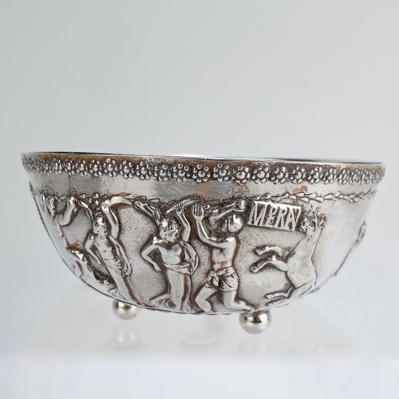 A wonderful Roman Revival bowl by E F Caldwell, one New York's most important historical design firm.

The bowl has a raised frieze-like decoration around it's circumference, rosettes to the top rim and rests on 3 ball feet.

It would serve as a
