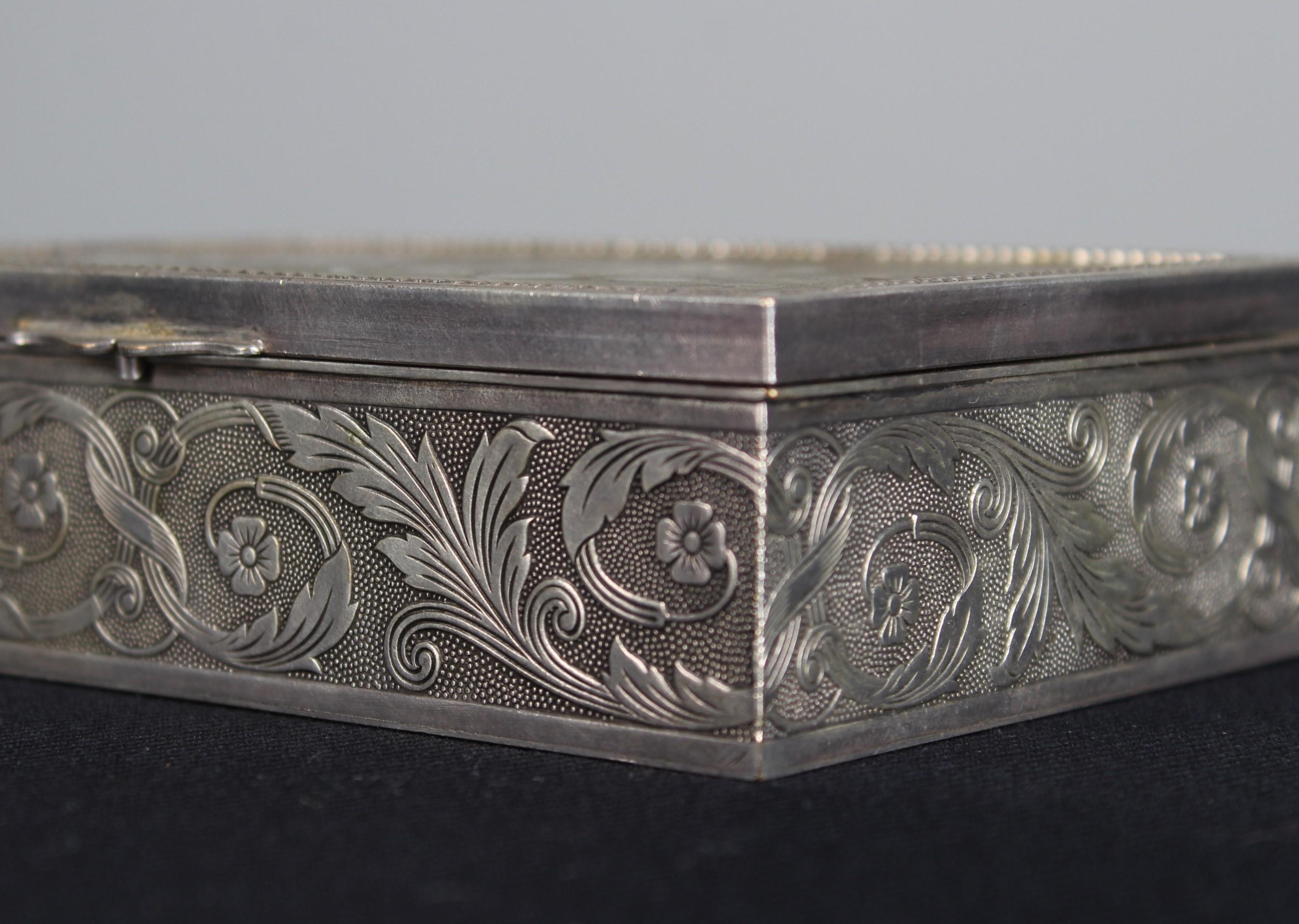 Beautiful silver-plated brass jewelry box, France, 1880s.
Fine flower tendrils and blossom decorations on all sides. The lid shows a scene from an taverne, the landlady pouring wine from a carafe for a musician. Beautiful attention to detail on the