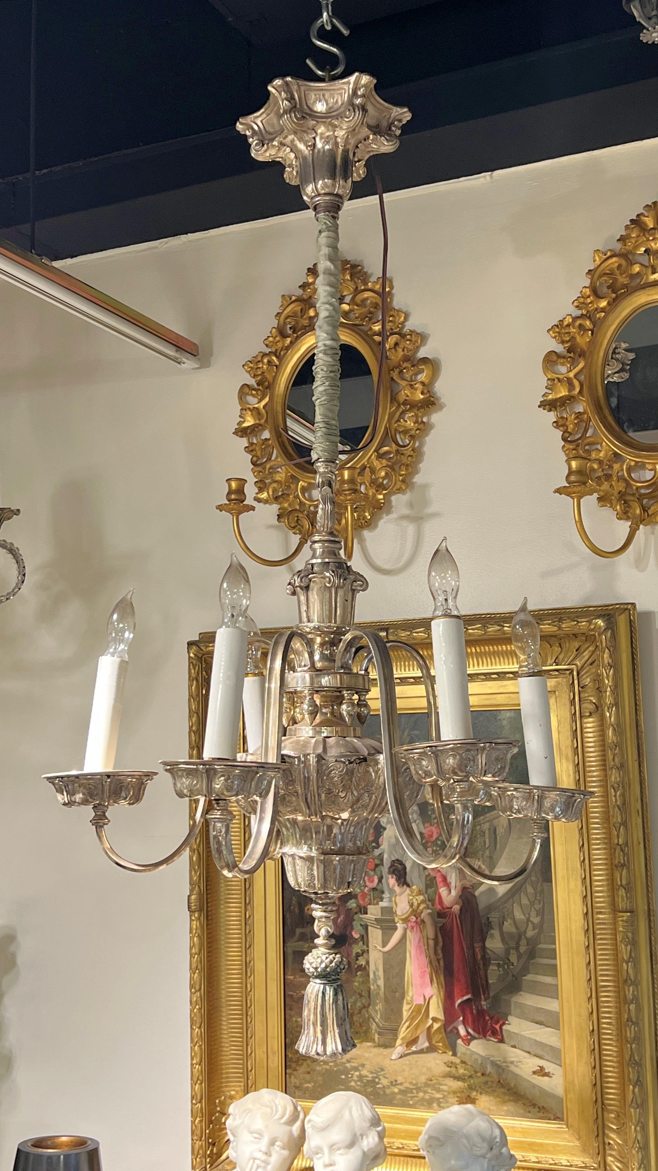Lustre en métal argenté de style néoclassique attribué à Edward F. Caldwell, mesurant 22 pouces de diamètre et 40 1/2 pouces de hauteur, avec plaque de plafond d'origine, chaîne décorative enveloppée de satin, six douilles électrifiées de taille
