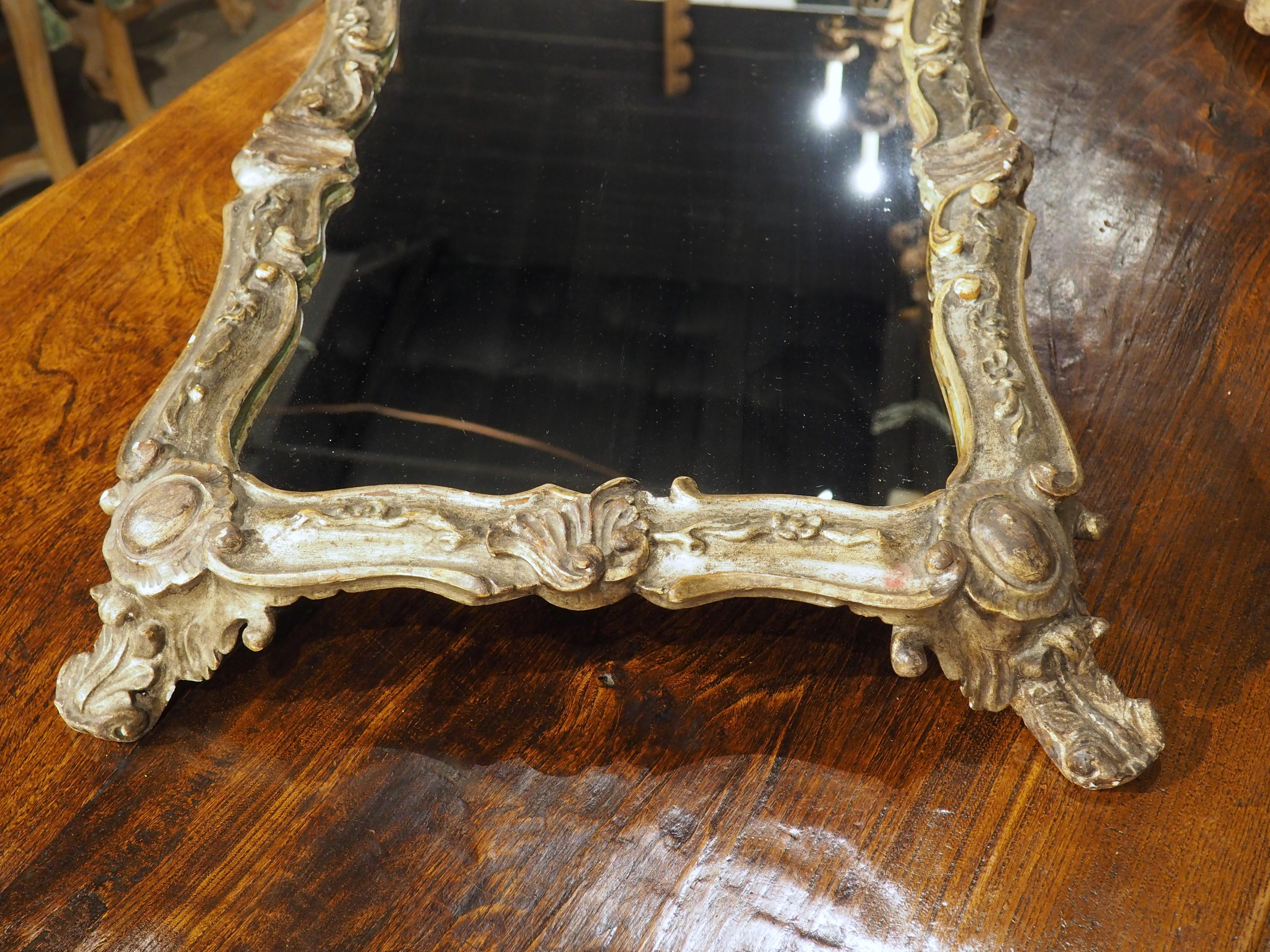 A beautiful surtout de table from Italy, circa 1900.  Hand-carved and silvered wooden frame surrounding a shaped piece of glass.

More information coming soon…