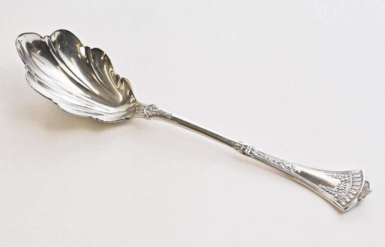 The antique silver plated sugar spoon has a leaf-like bowl and a handle embellished with Victorian flowers, leaves and tassels. Stamped Rogers & Bro.