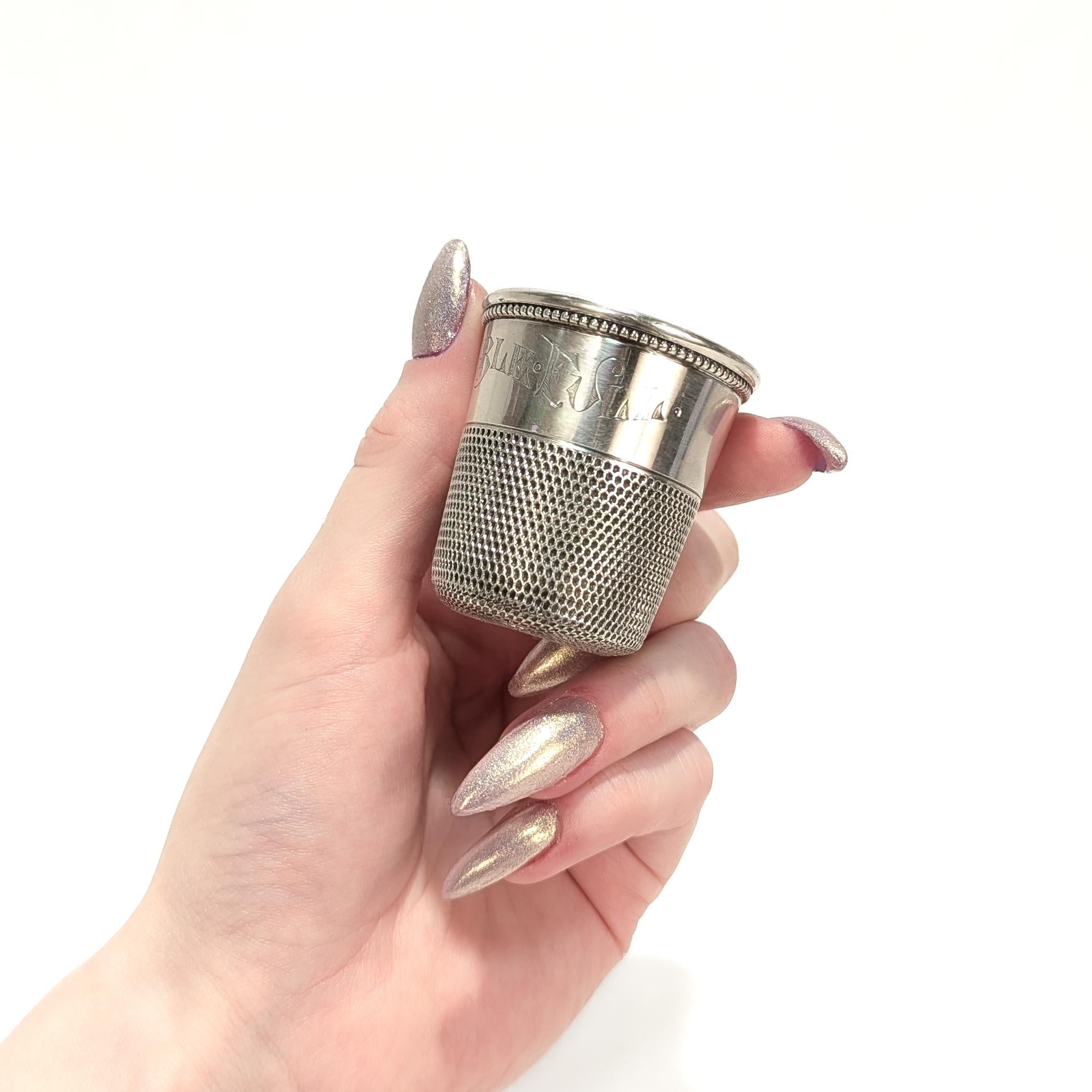 A fine, signed antique sterling silver liquor measure or jigger.

In the form of an over-sized silver thimble. 

Engraved around the rim 