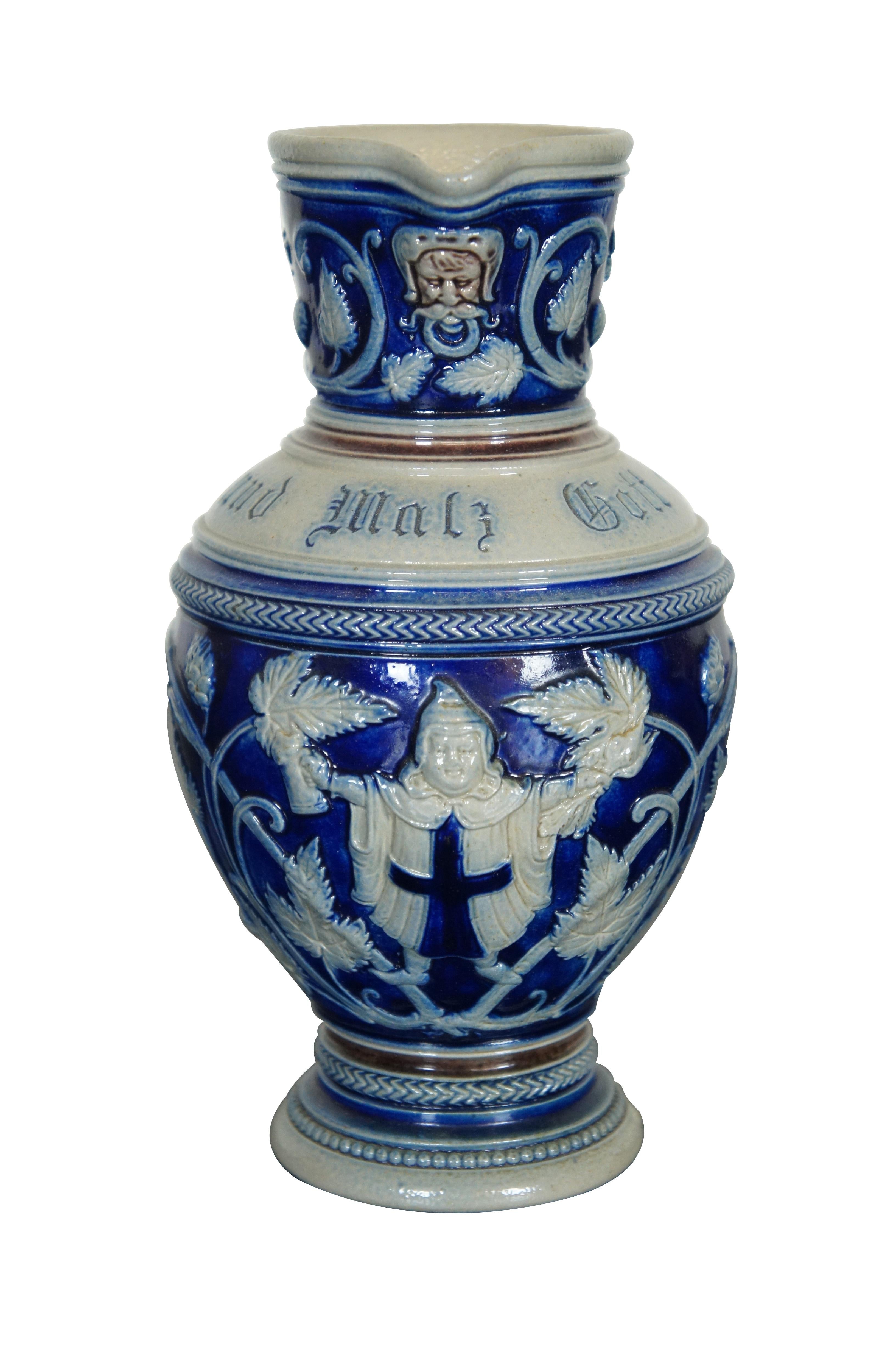 A lovely antique SImon Peter Gerz Stein / pitcher.  Blue and white salt glaze with a monk at the center wrapped within scrolling hops and barley.  Text reads: Hopfen und Malz Gott erhalt’s! Hops and malt, may the Lord preserve it.  The pitcher has a