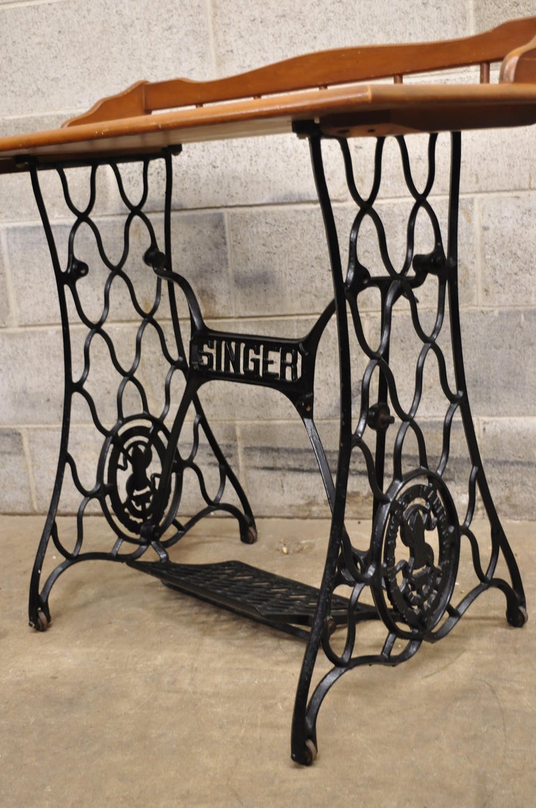 Antique singer sewing machine cast iron Victorian base maple console table desk top. Item features cast iron singer sewing machine base, wooden top with backsplash, very nice antique item, quality American craftsmanship, great style and form, circa