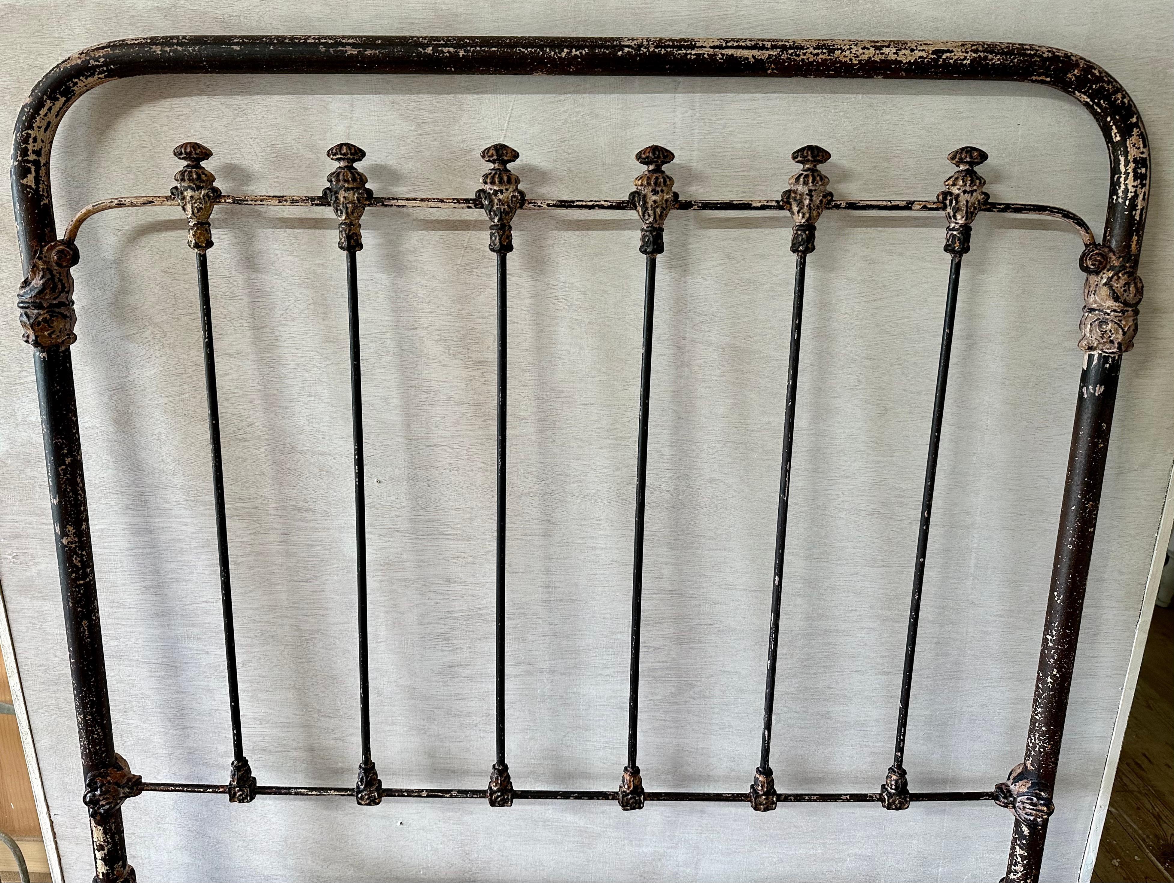 The antique country iron twin size headboard has a wonderfully, natural distressed look with just enough paint remaining to add interest and character.  
We have cleaned it up and has been clear coated to prevent remaining paint from peeling and