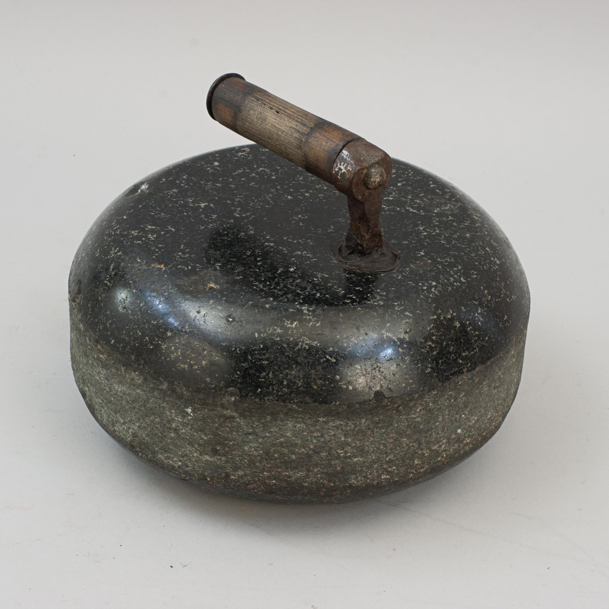 Antique Granite Curling Stone.
A late 19th or early 20th century single-soled curling stone with a metal and wood handle. The handle is permanently fixed with lead into a hole that is bored into the top of the stone.

The stone is 25 cm in diameter