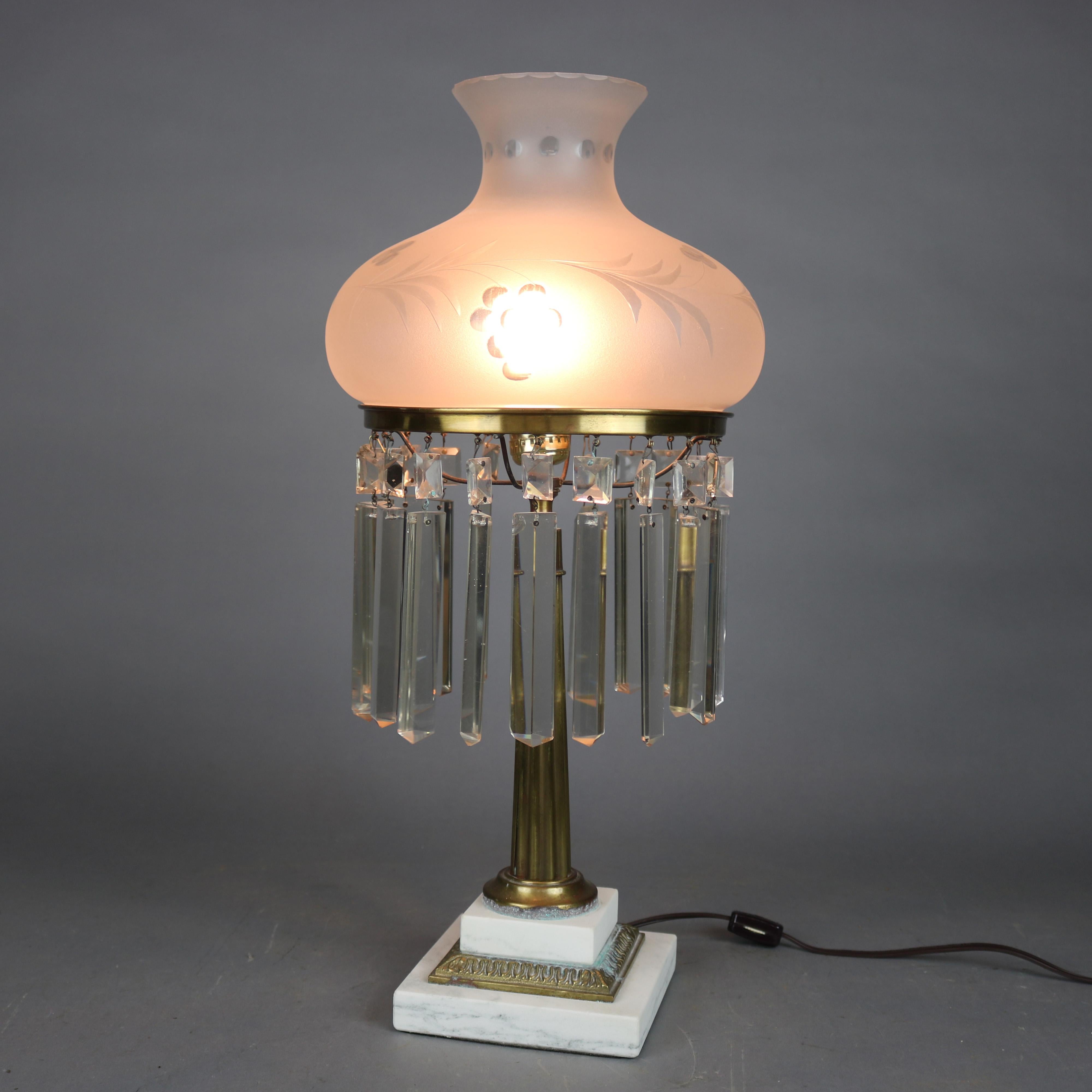 An antique Sinumbra style table lamp offers etched frosted shade with hanging prisms surmounting gilt metal single socket base having reeded column seated on stepped marble base, circa 1930

Measures: 21